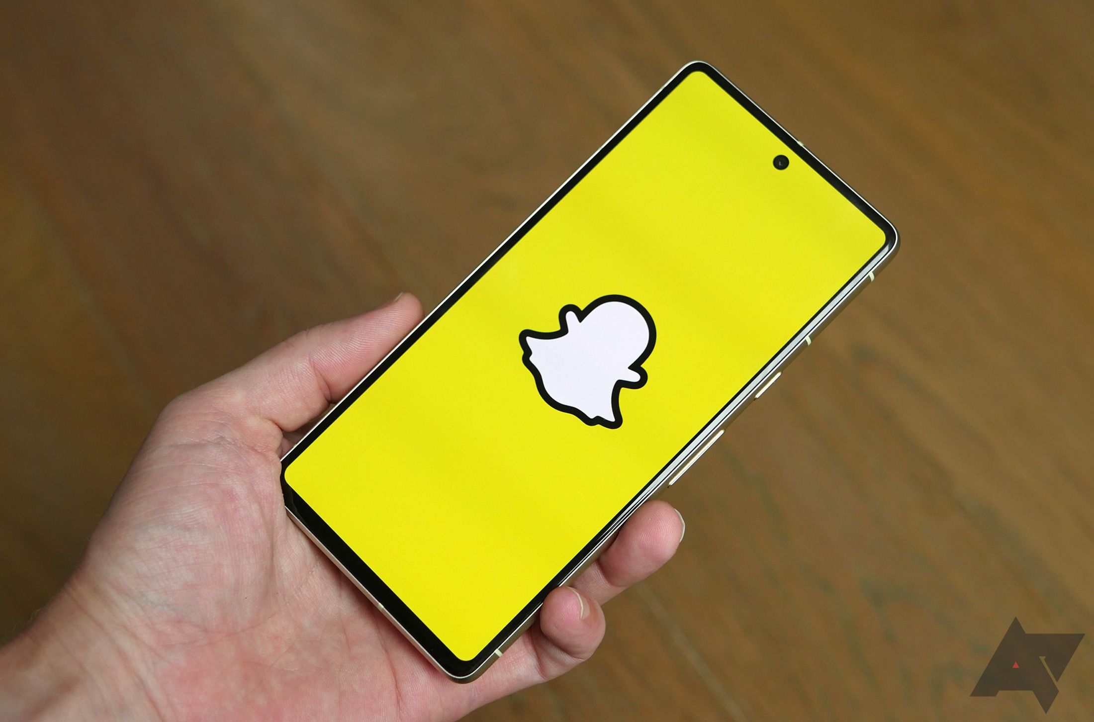 Mão segurando um smartphone com aplicativo Snapchat