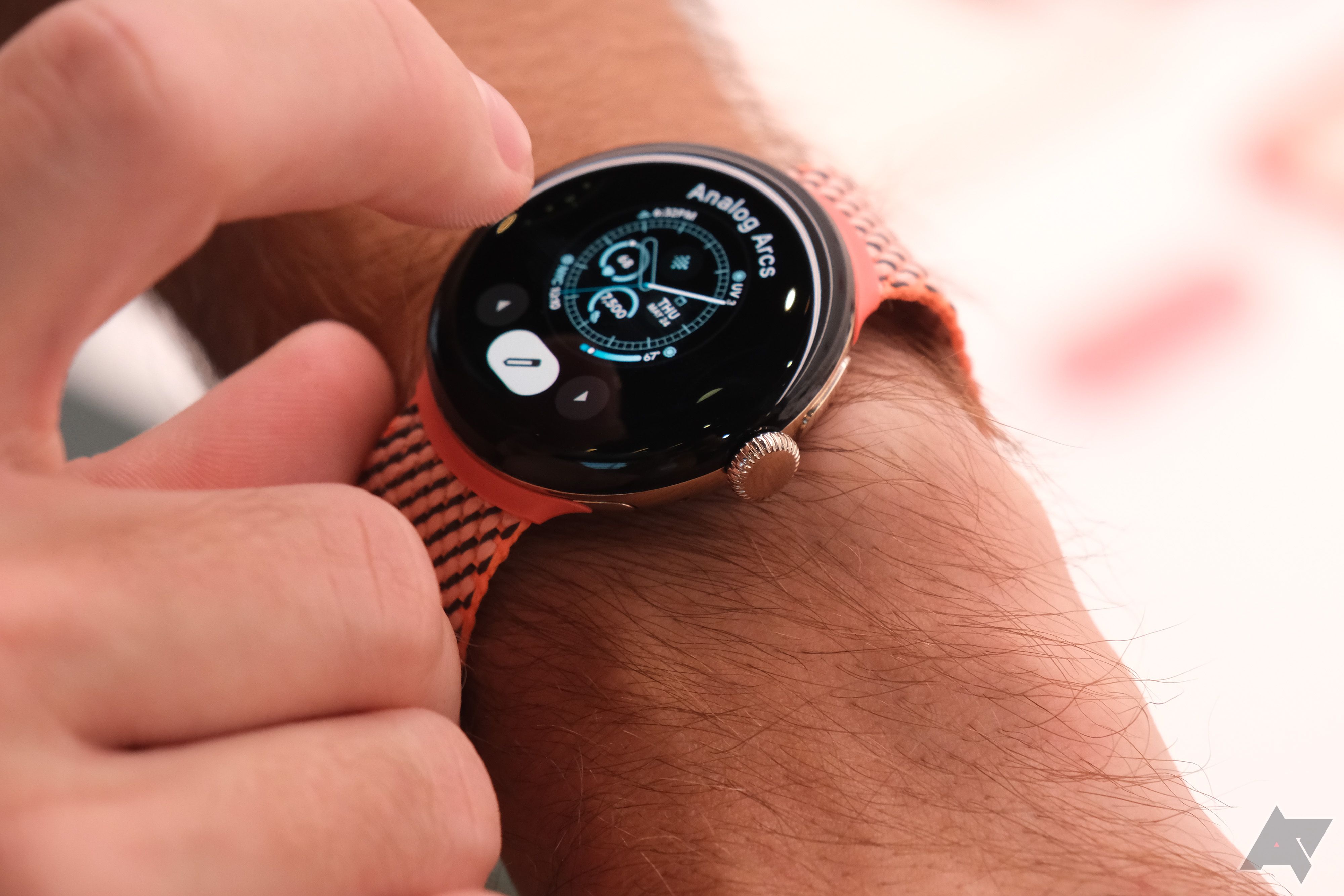 Uma mão faz ajustes na tela de um smartwatch. 