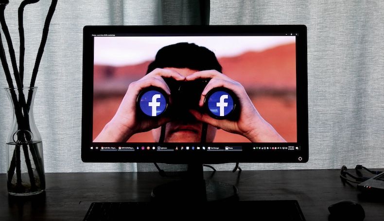 Pessoa na tela do monitor olhando pela imagem do herói dos binóculos do Facebook
