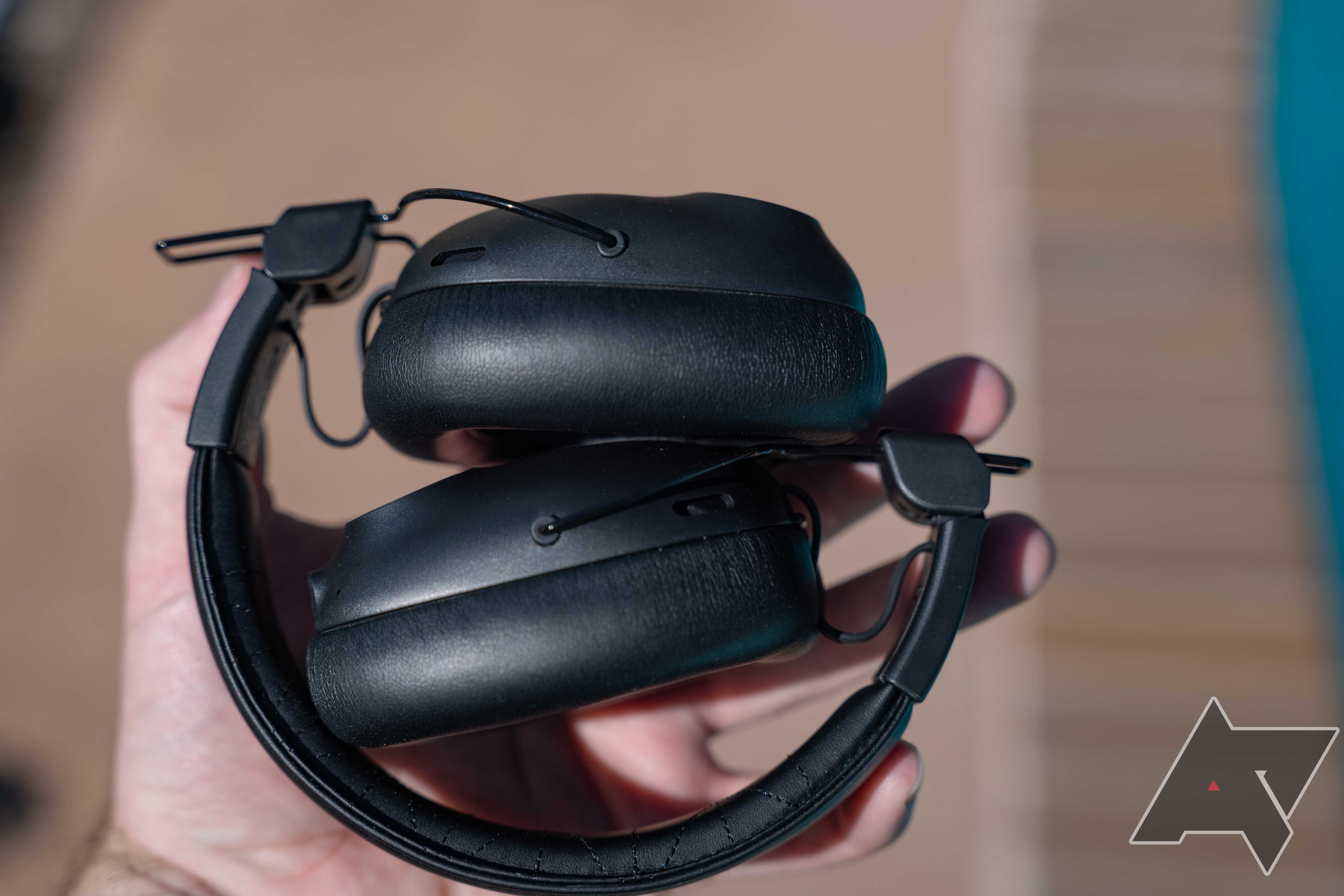 Os fones de ouvido JLab Studio Pro ANC dobrados para armazenamento na palma da mão