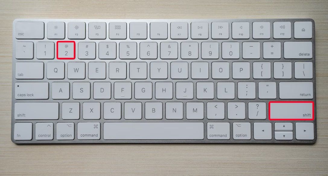 Teclado de computador branco mostrando o atalho de teclado Shift+2