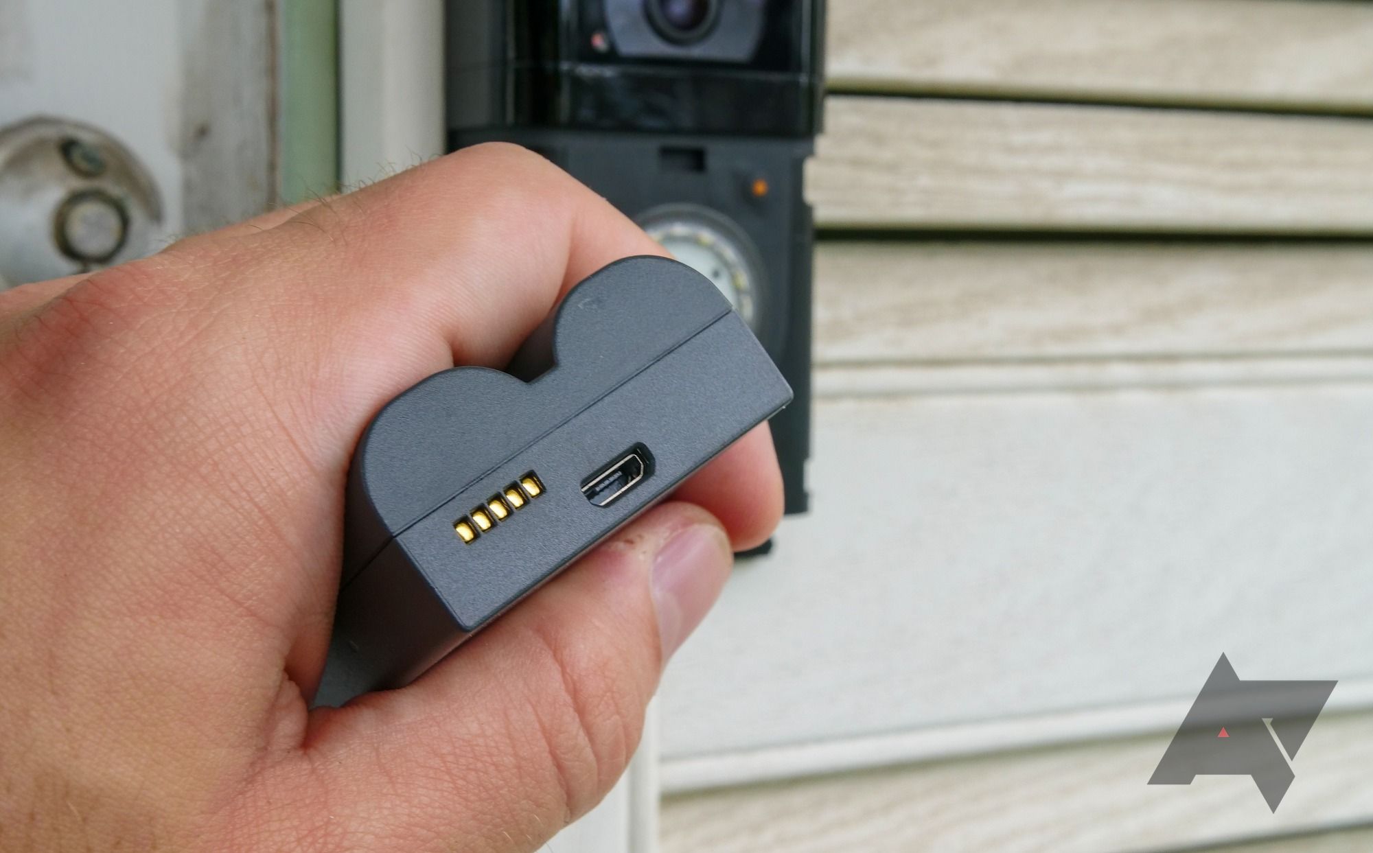 Uma mão segurando a bateria Ring Video Doorbell 4
