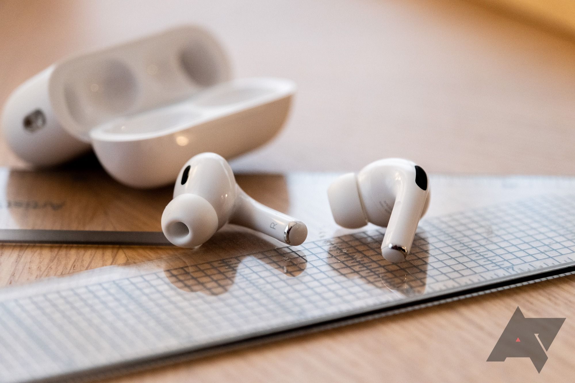 Airpods na mesa ao lado de uma caixa aberta.