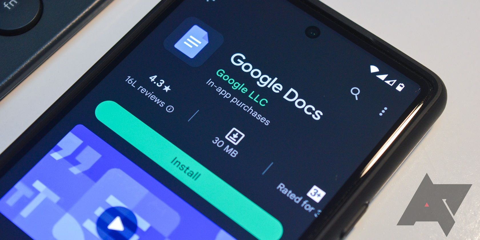 A imagem mostra um smartphone Android sobre uma mesa, com a tela do telefone aberta na página de download do Google Docs na Google Play Store.