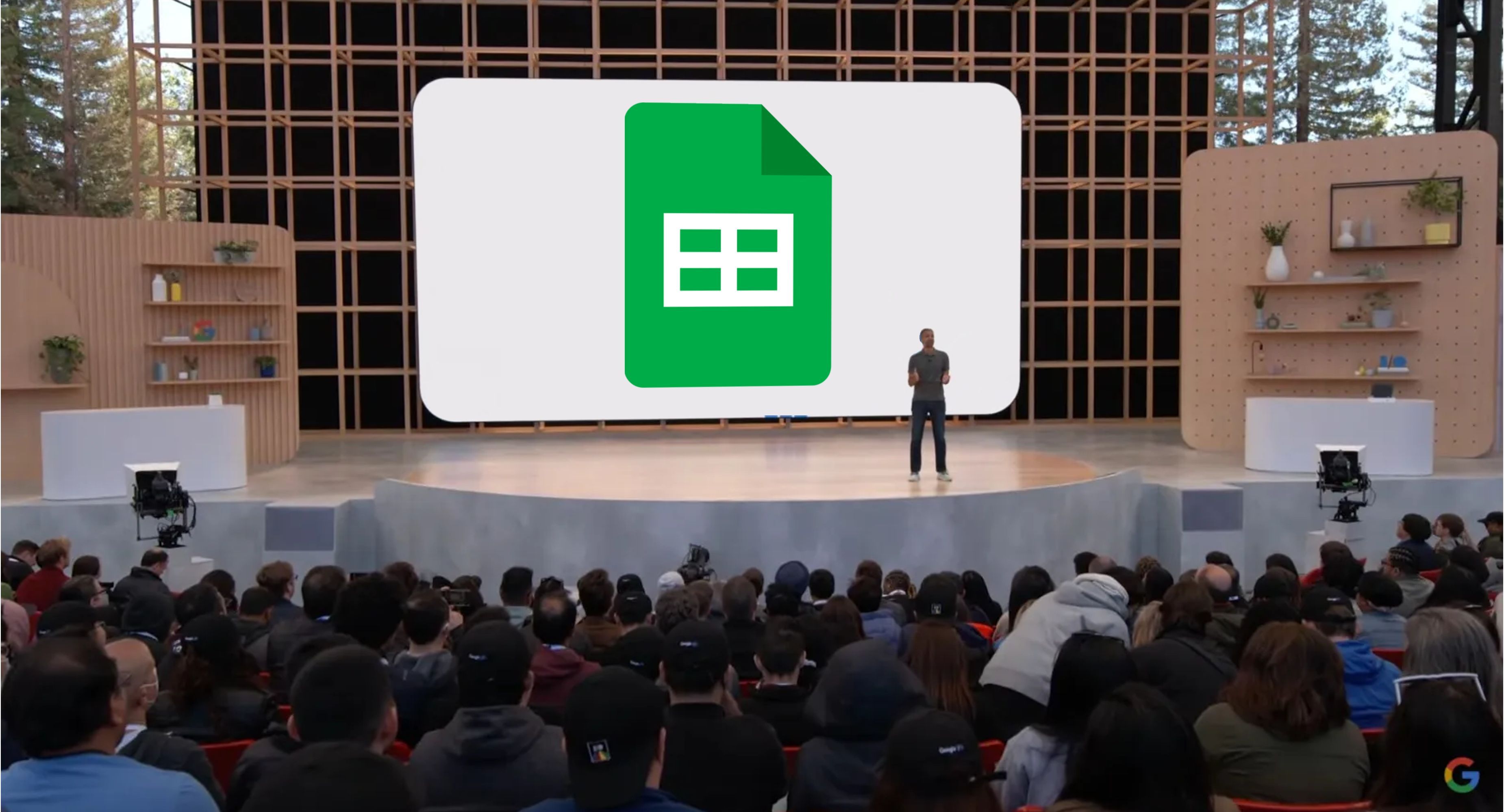 Um apresentador do Google fica em frente a uma tela de apresentação com um logotipo de folhas grandes