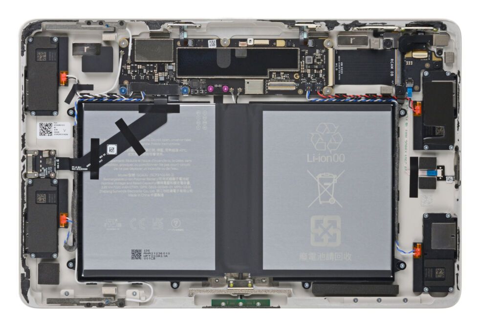 Uma visão de cima para baixo do Google Pixel Tablet aberto com bateria e outros componentes visíveis