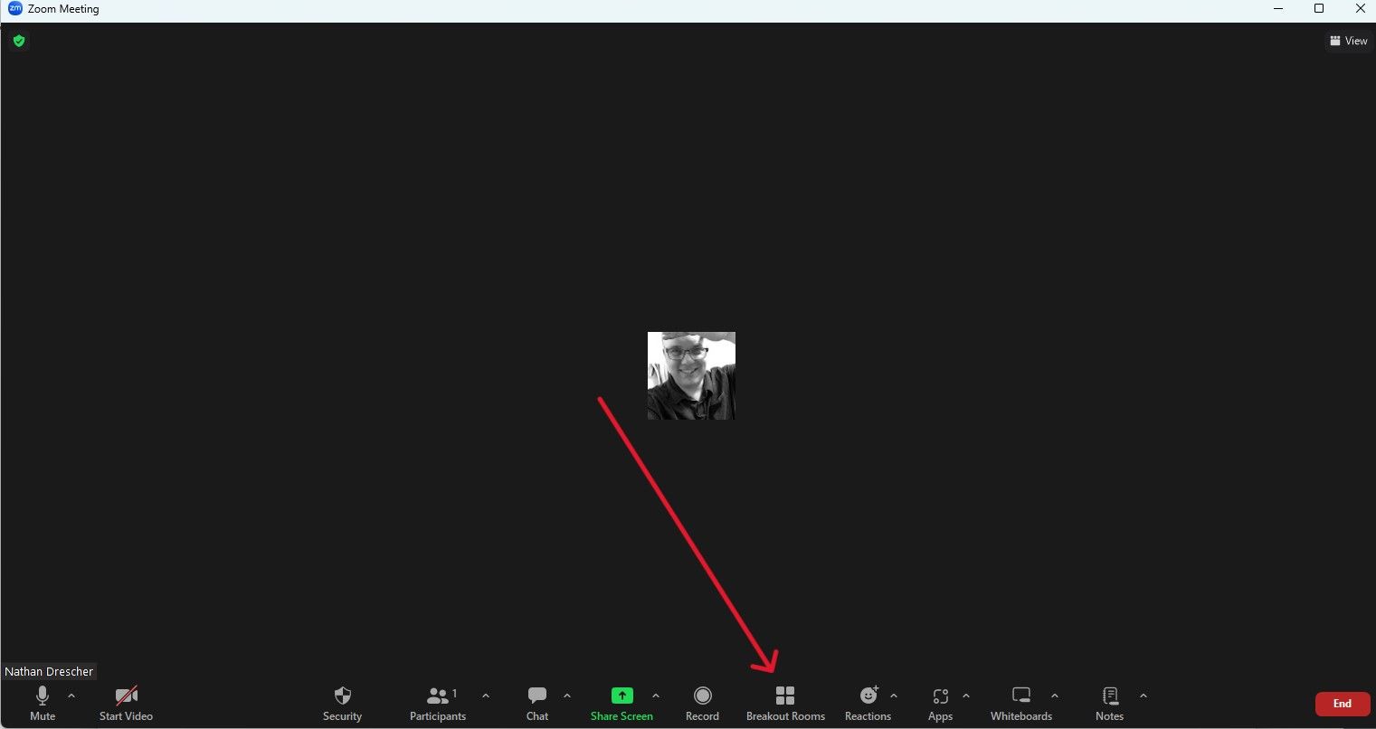 Uma reunião Zoom com uma seta vermelha apontando para BreakoutRooms na parte inferior da tela.