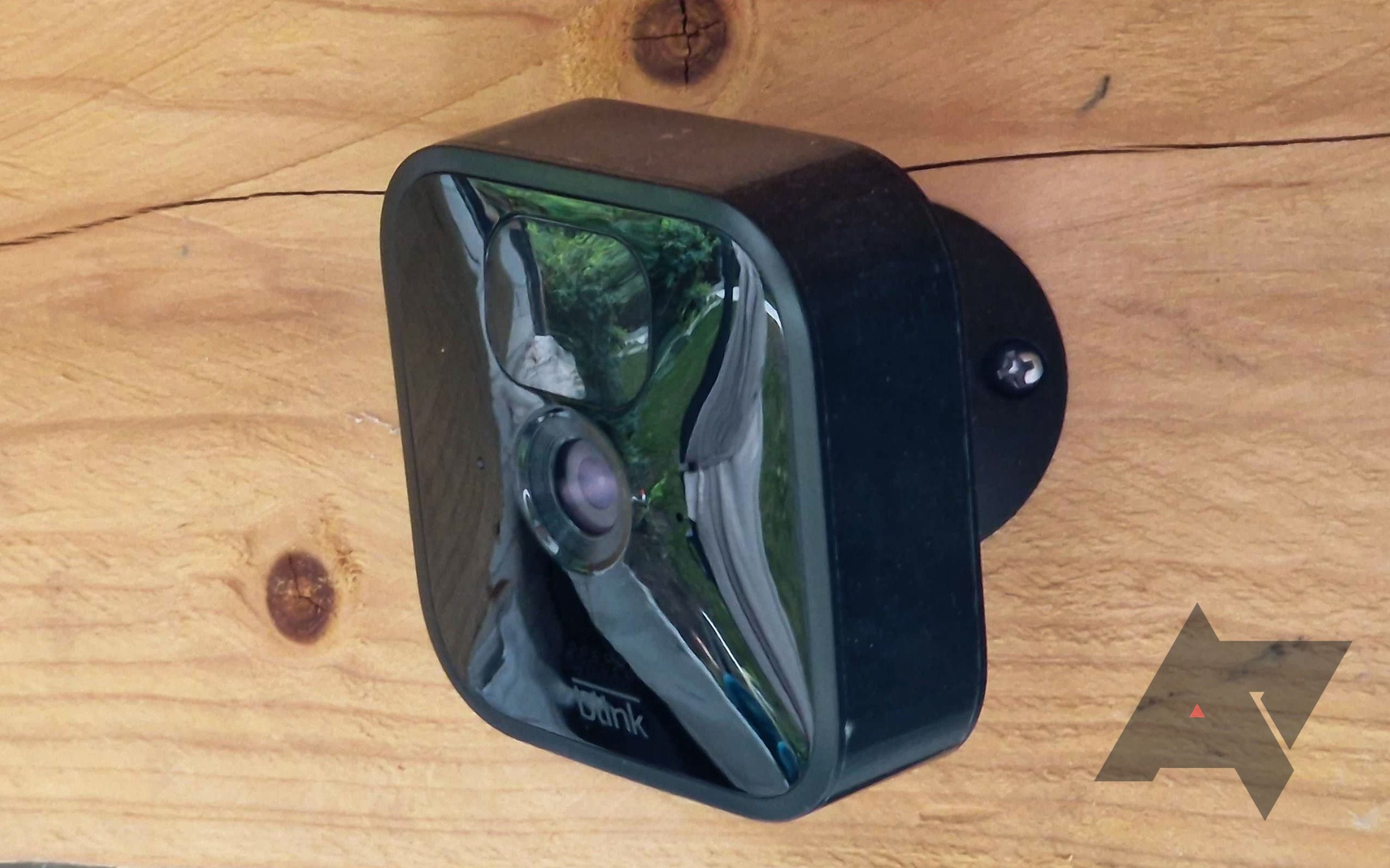 Uma câmera externa Blink montada em um pedaço de madeira.
