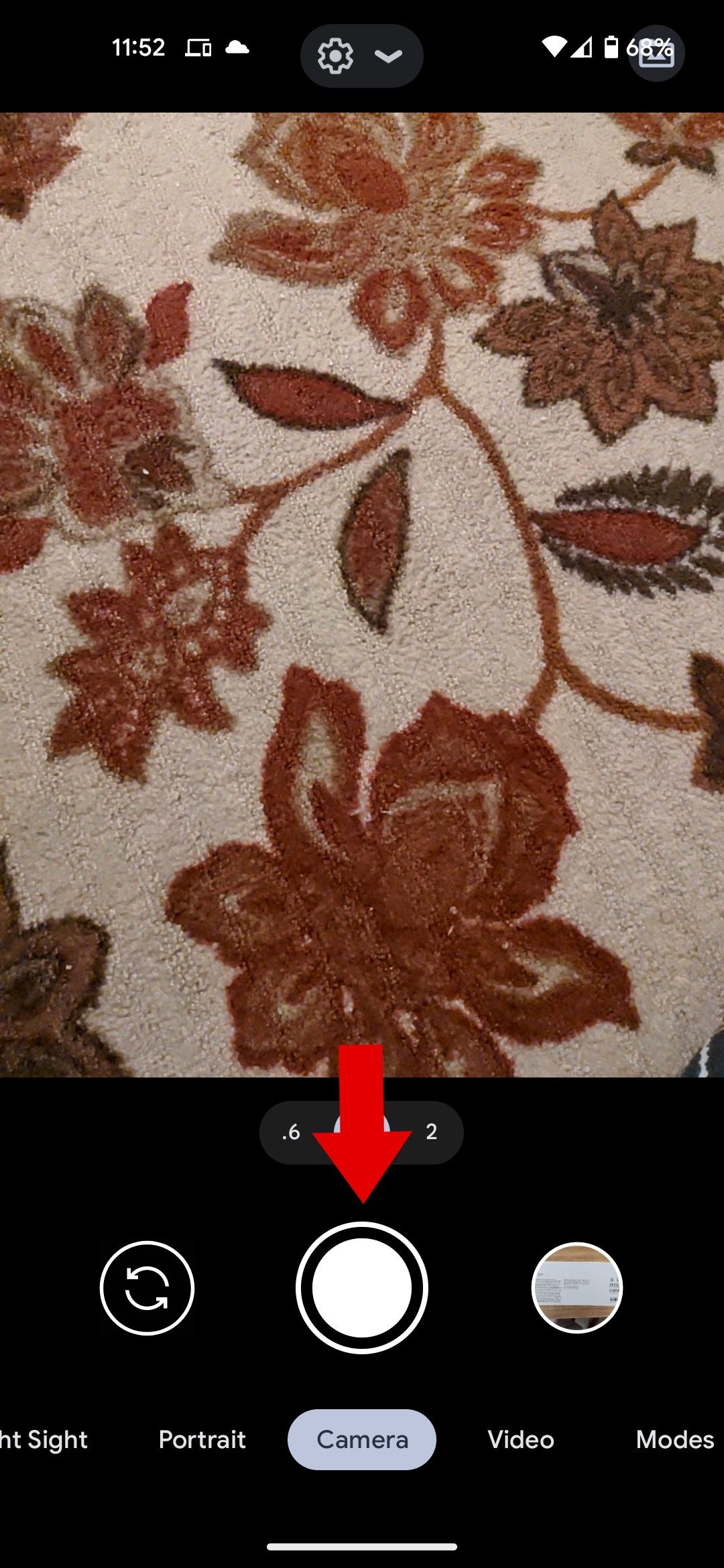 O aplicativo da câmera do Google com uma seta vermelha apontando para o botão do obturador.