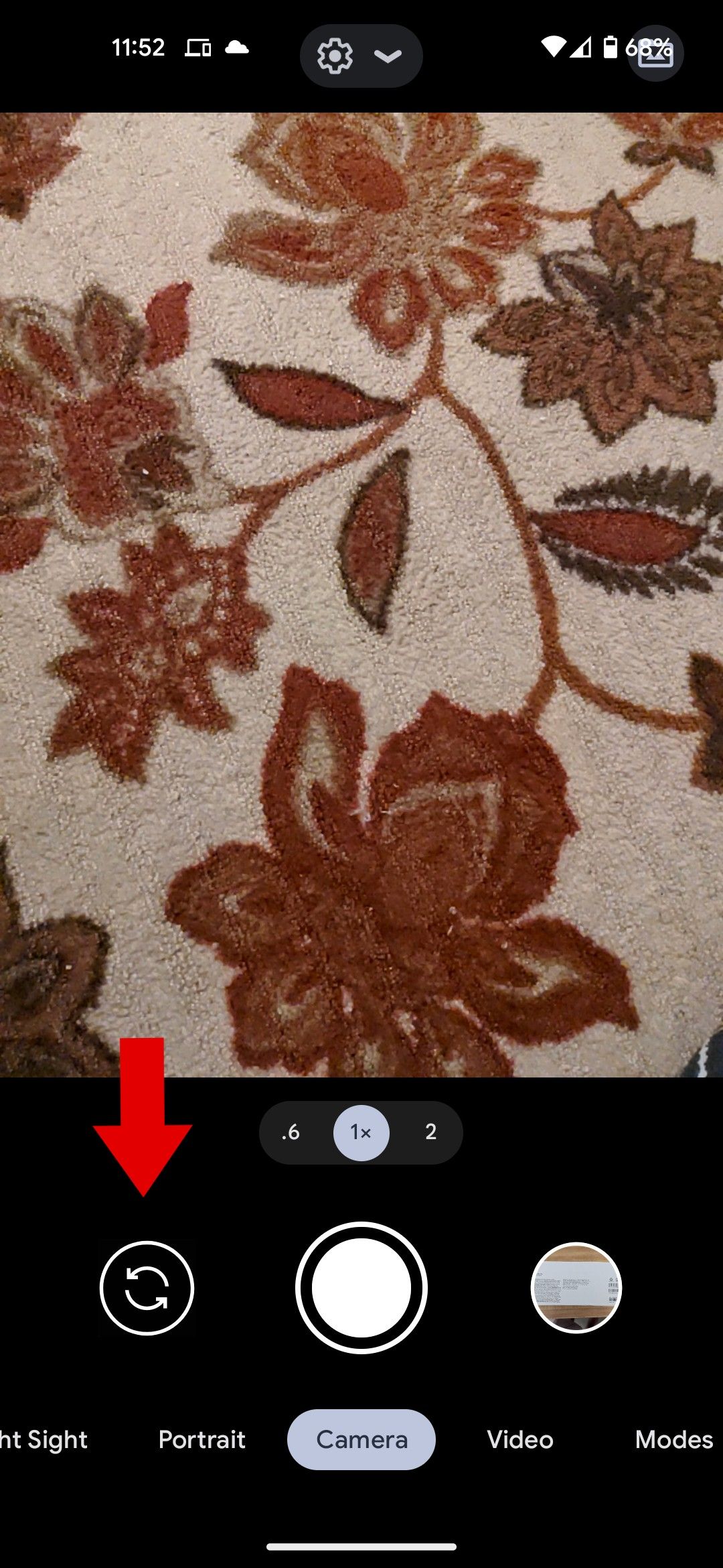 O aplicativo da câmera do Google com uma seta vermelha apontando para o botão de alternância da câmera.