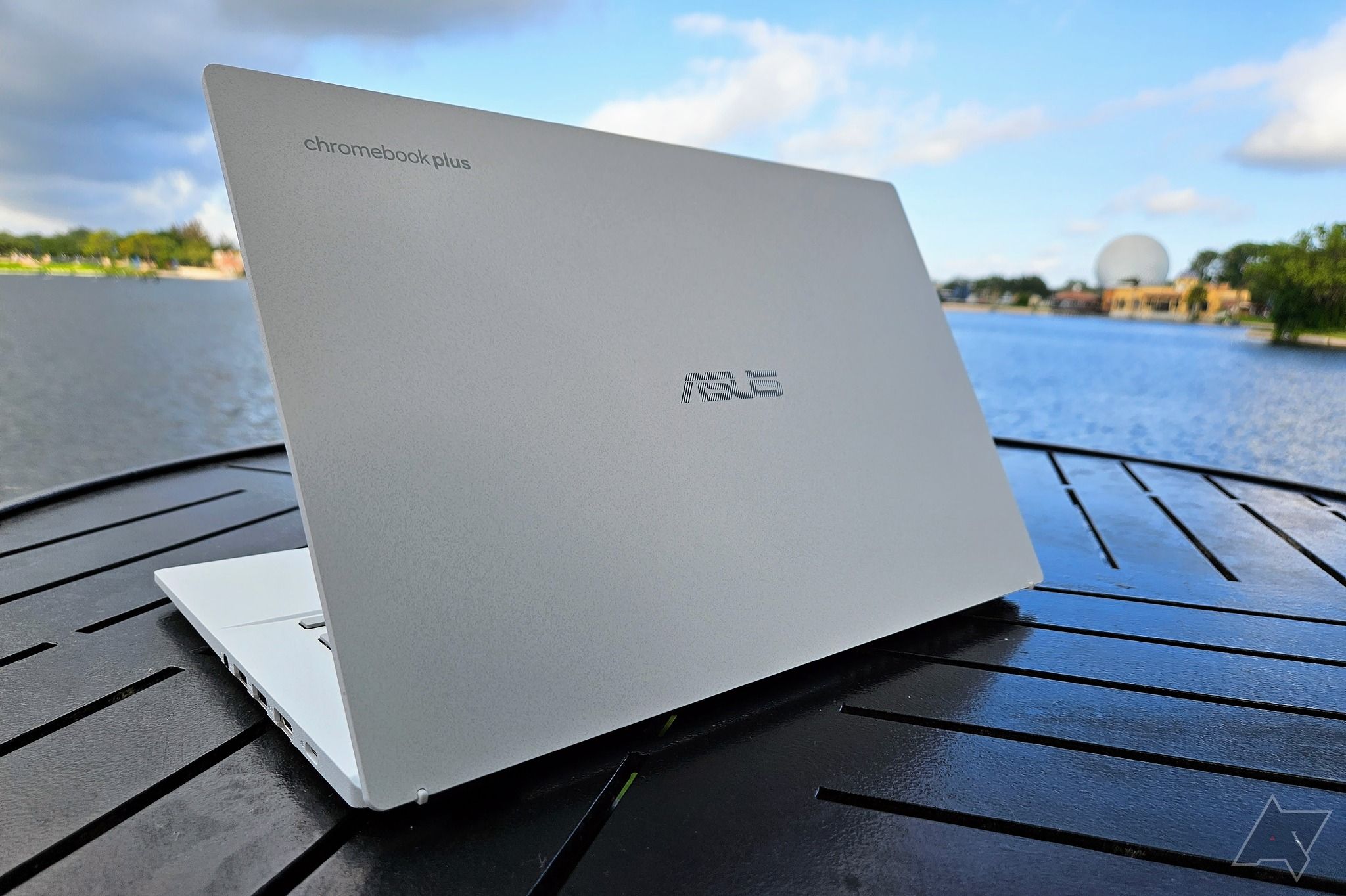 Asus Chromebook Plus CX34 sentado em um banco perto da praia.