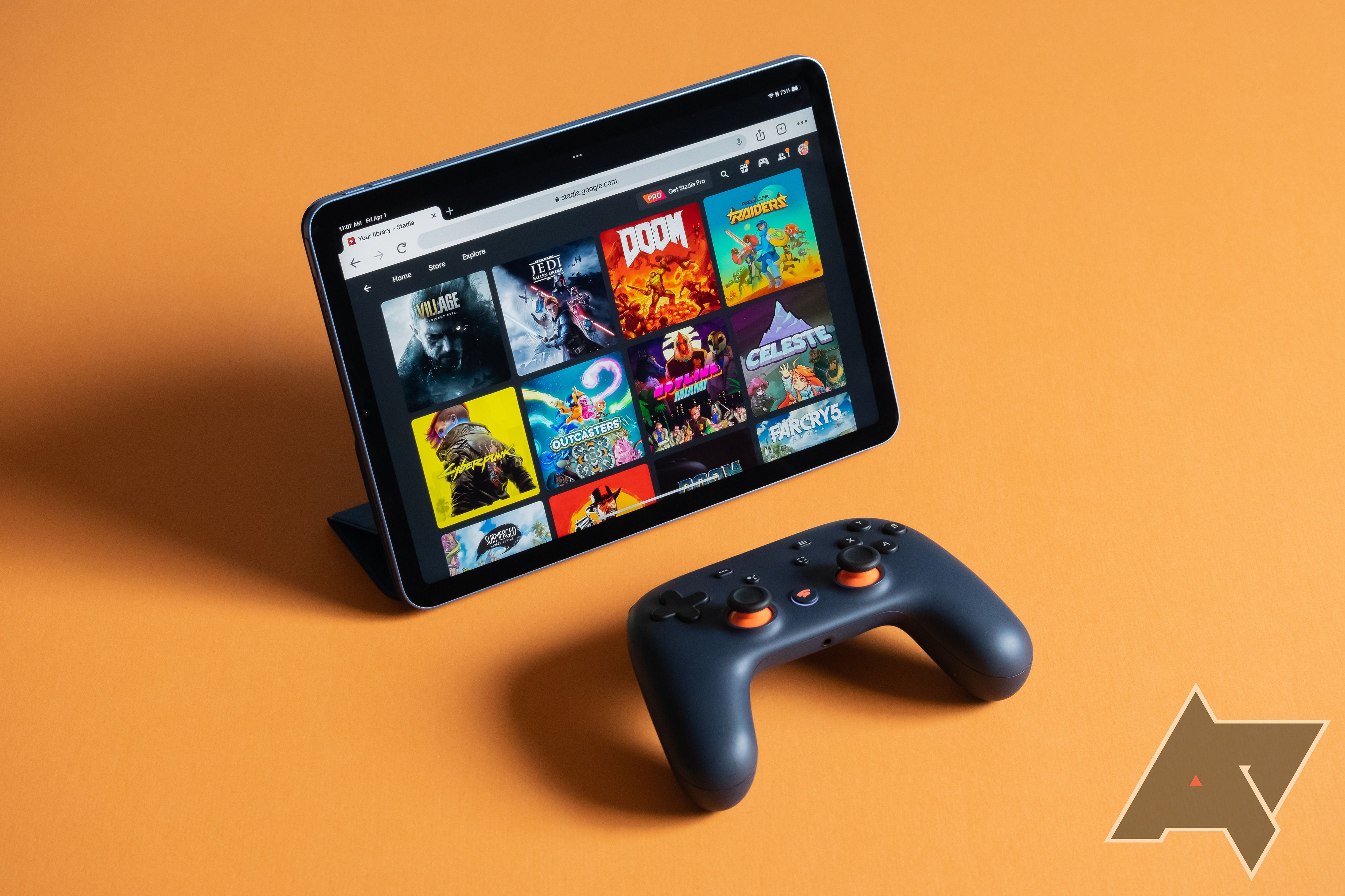 Google Stadia em um iPad Air com um controlador Stadia na frente em um fundo laranja