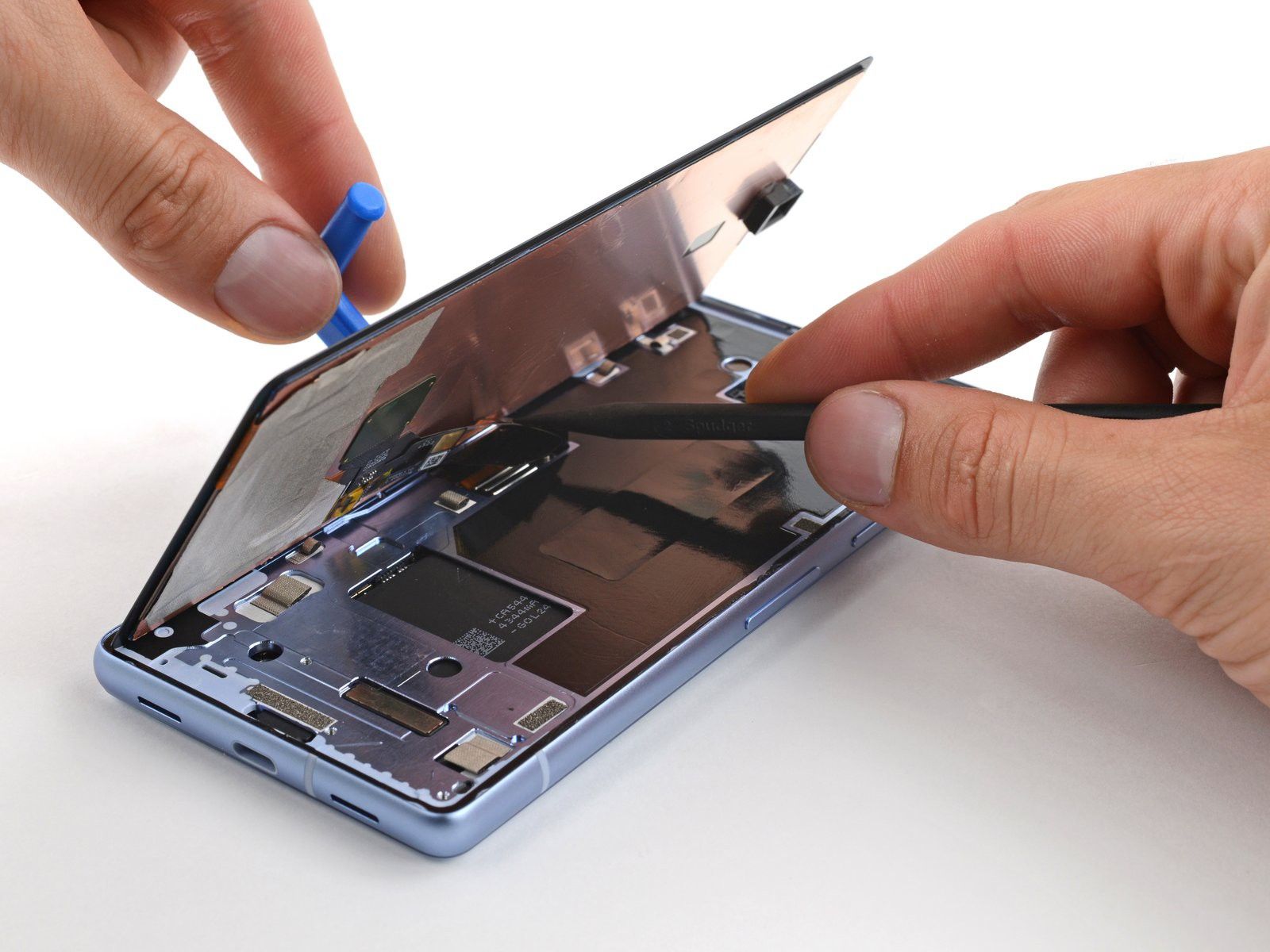 Um Pixel 7a sendo consertado com a tela removida do corpo do telefone