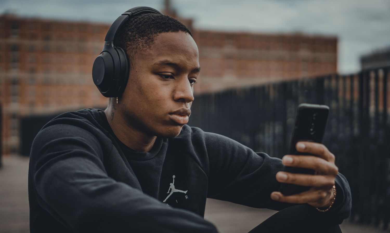 Um homem olha para o telefone enquanto ouve música