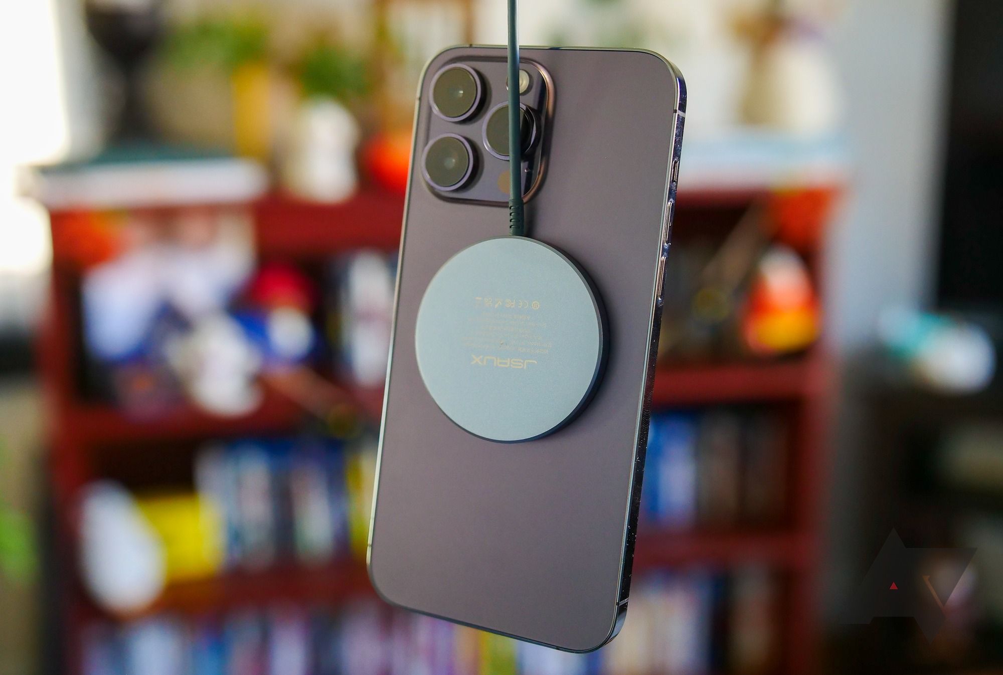 Apple iPhone com carregador MagSafe conectado.