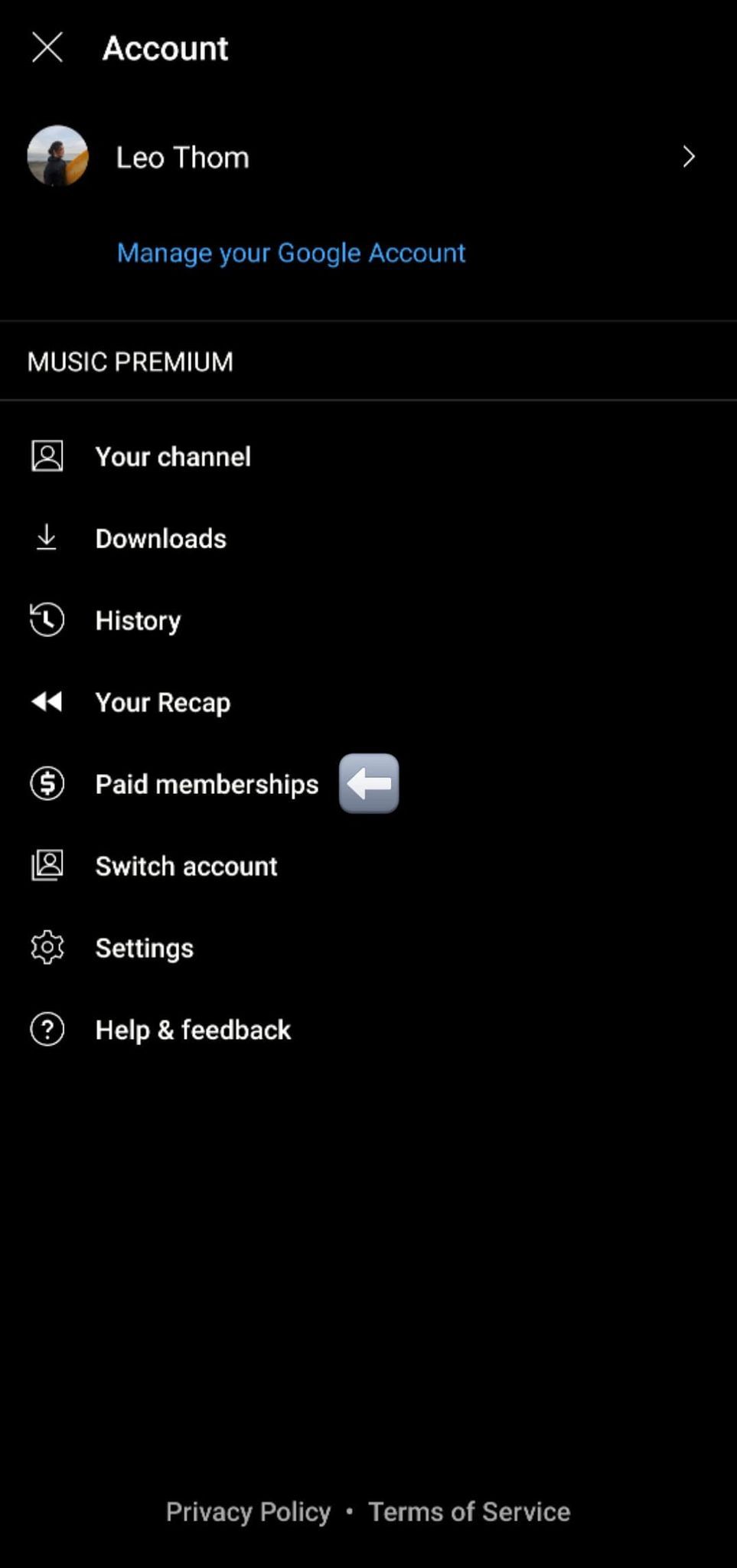 A página da conta no aplicativo YouTube Music para Android com uma seta branca em uma caixa cinza apontando para 