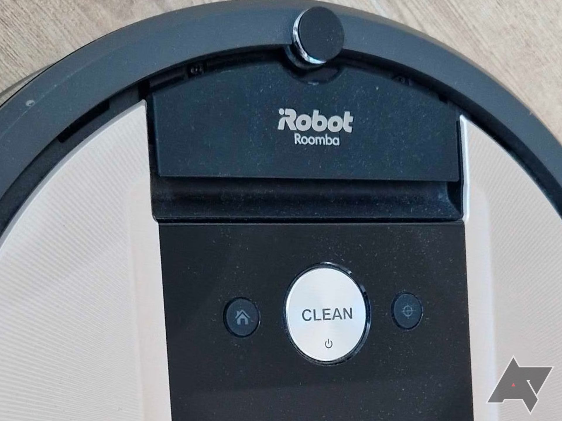 Um close de um aspirador Roomba mostrando seus botões físicos