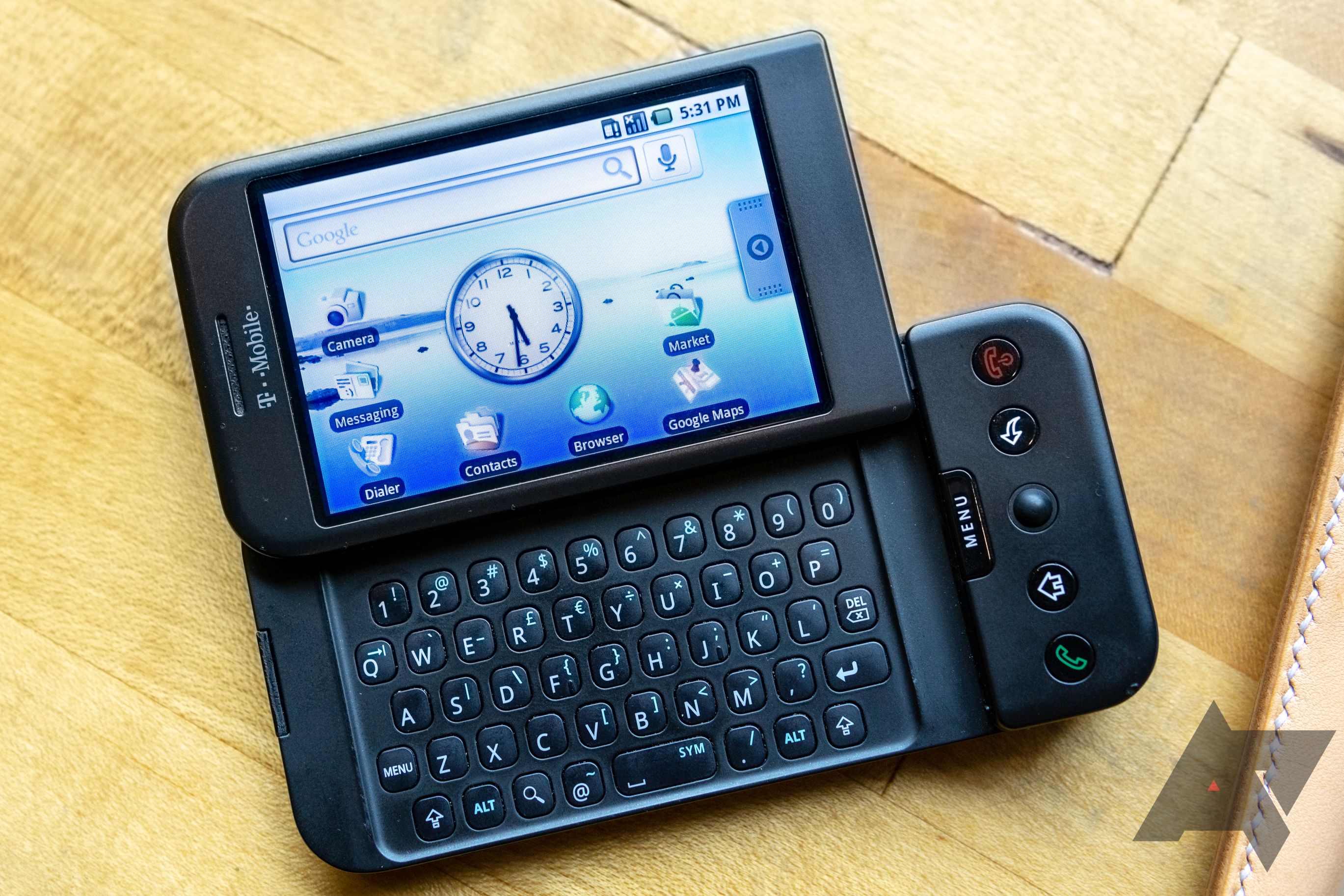 HTC Dream/T-Mobile G1 deitado na mesa com tela aberta e teclado à mostra
