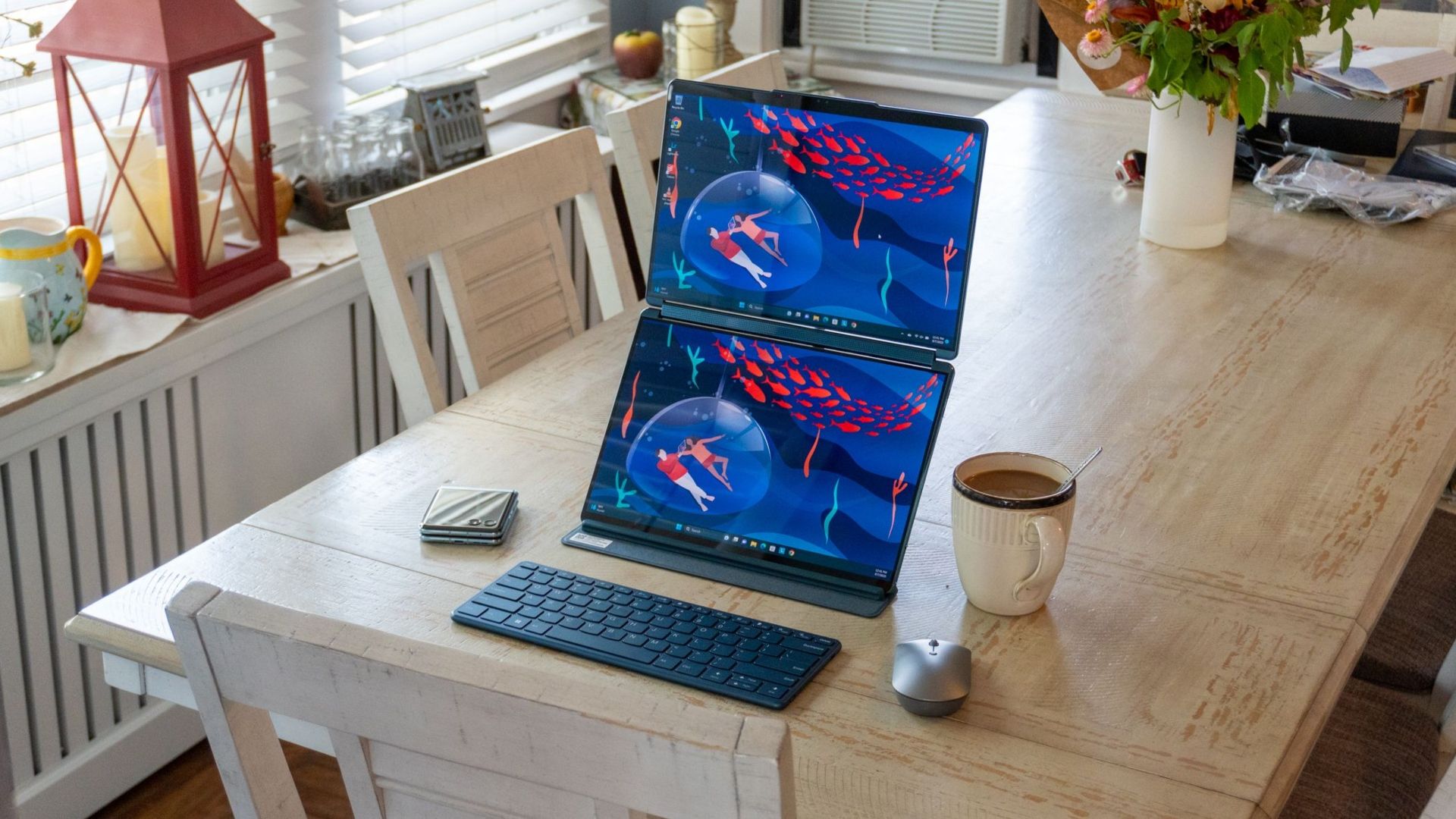 Lenovo Yoga Book sobre uma mesa com uma xícara de chá, um mouse e um teclado ao lado