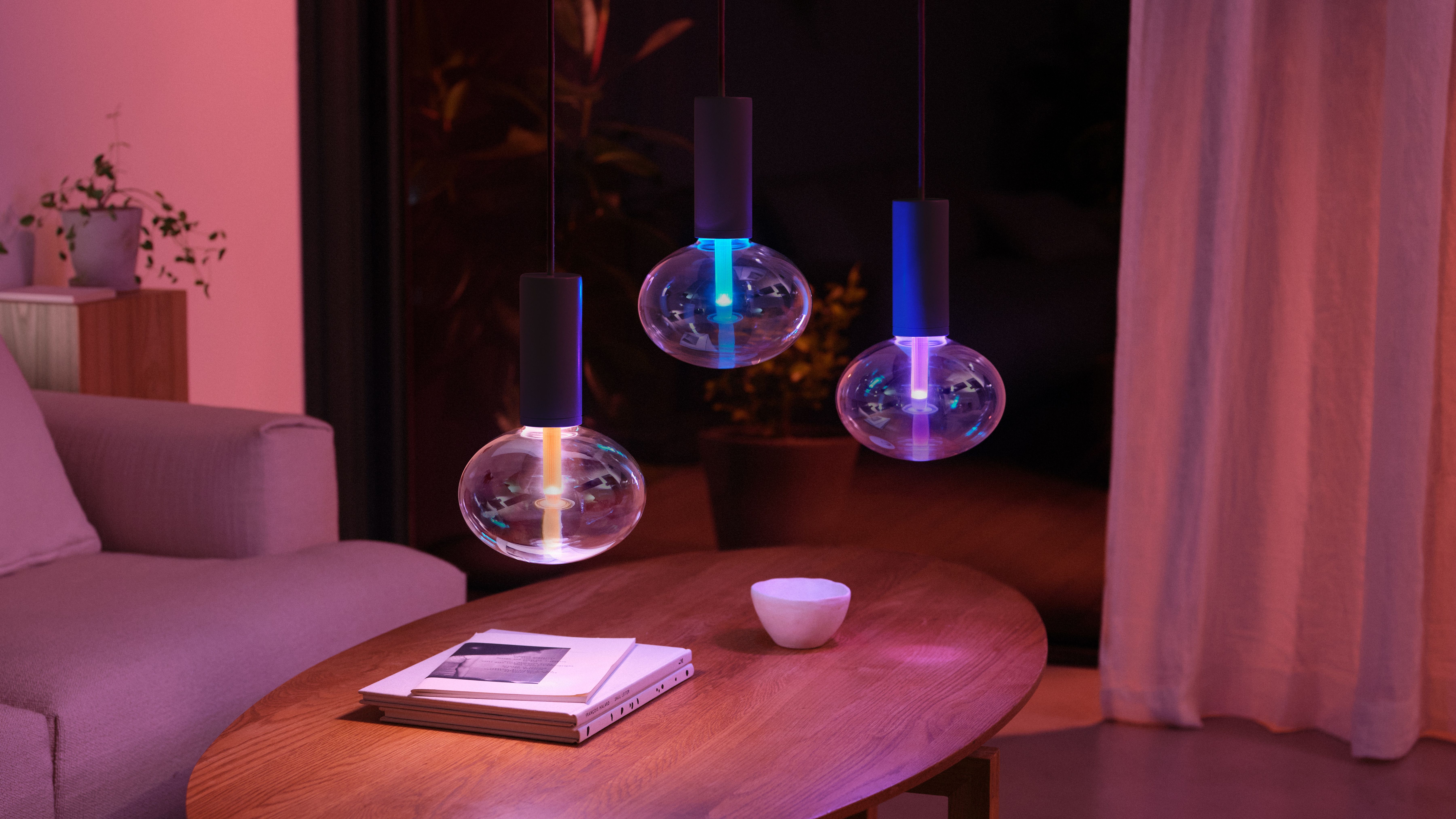 Três luminárias pendentes Philips Hue sobre uma mesa de centro
