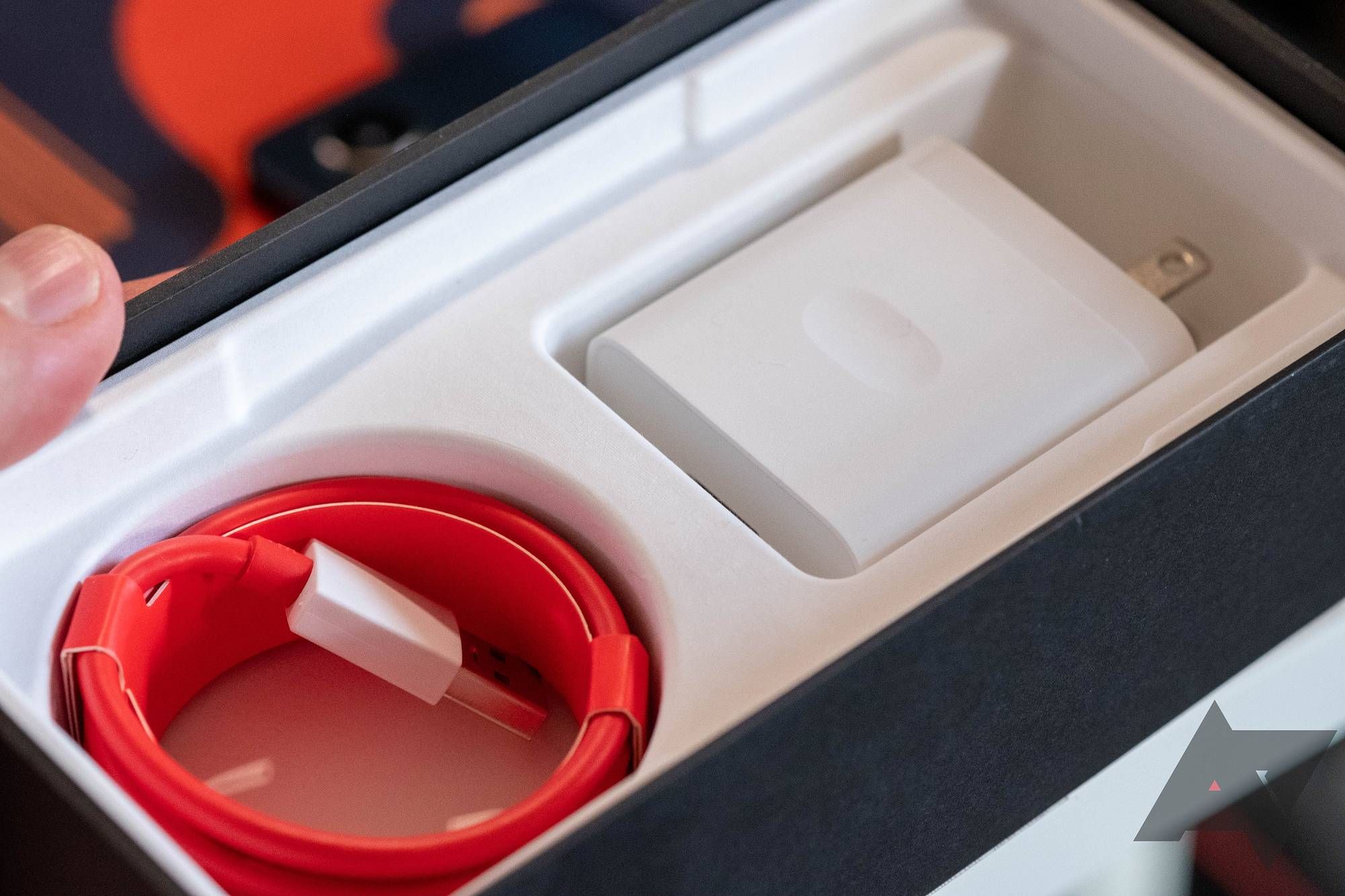 Uma caixa de telefone OnePlus com carregador dentro.