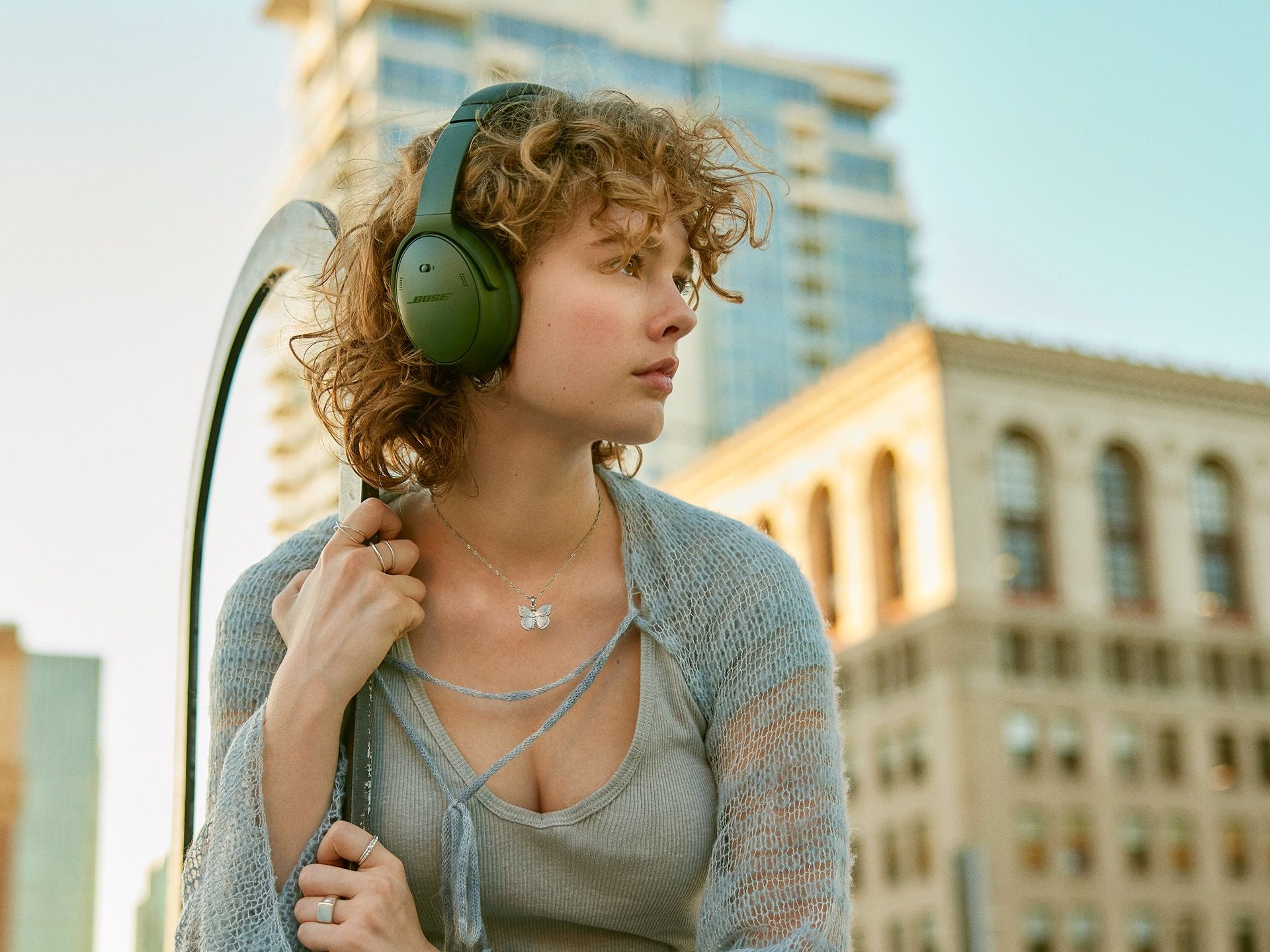 Uma mulher em uma cidade usando fones de ouvido verdes