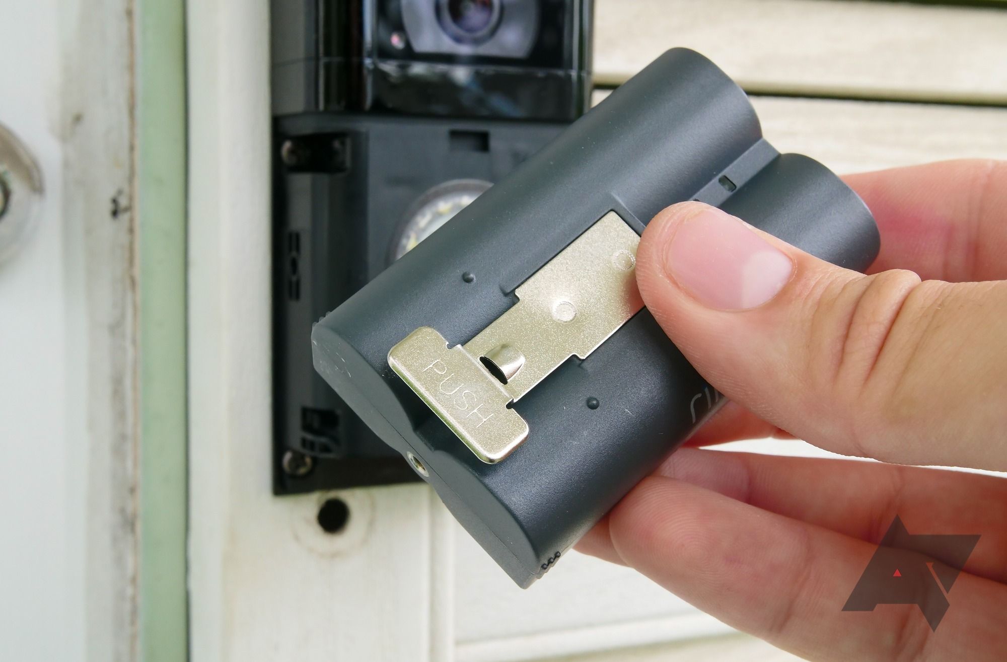 Uma pessoa substituindo a bateria do Ring Video Doorbell 4
