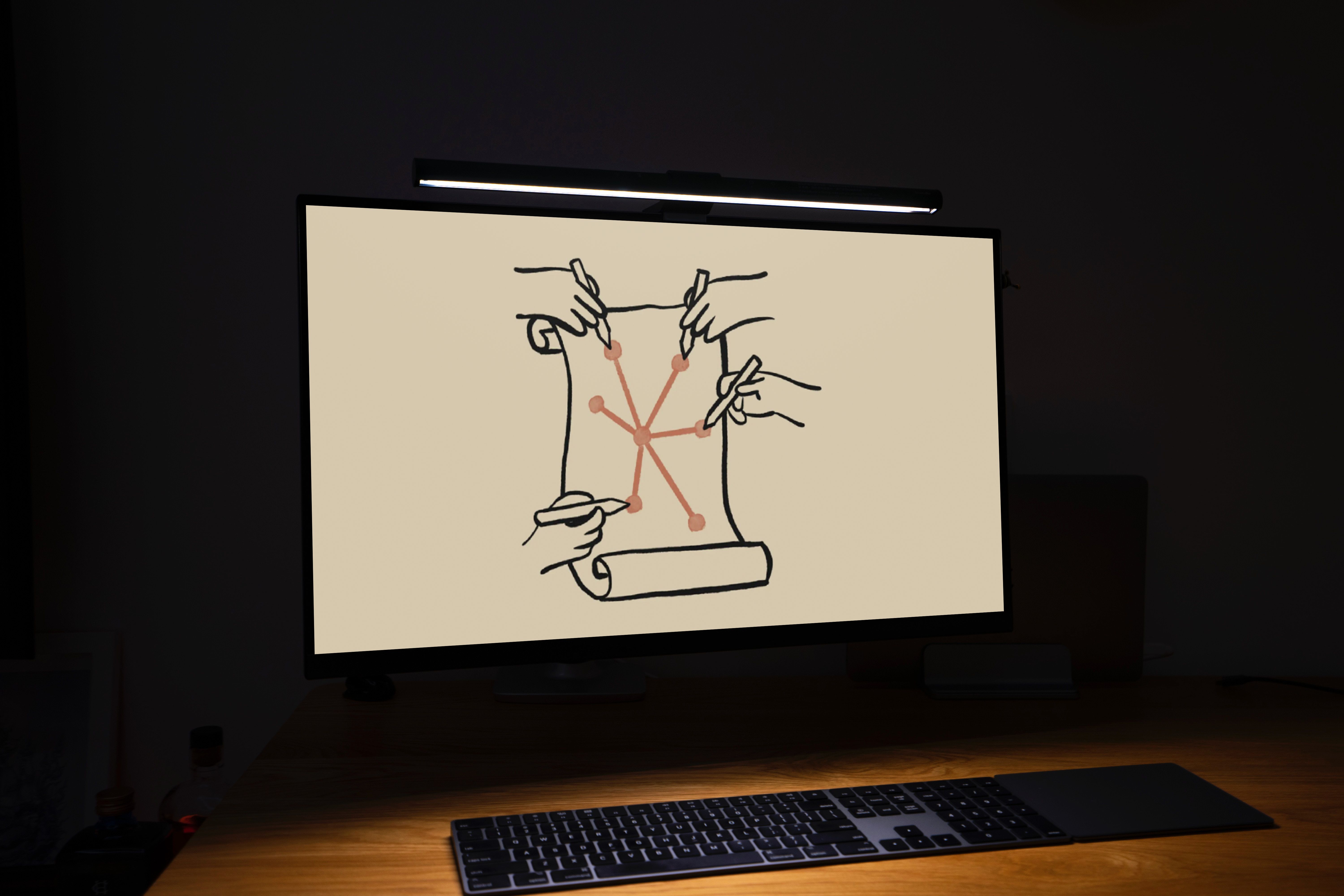 Um monitor em uma sala escura exibindo uma imagem desenhada à mão de quatro mãos desenhando em um pergaminho