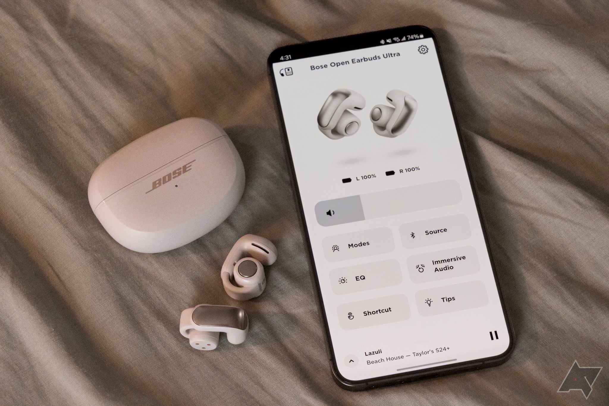 Os fones de ouvido Bose Ultra Open ao lado de um smartphone executando o aplicativo Bose Music