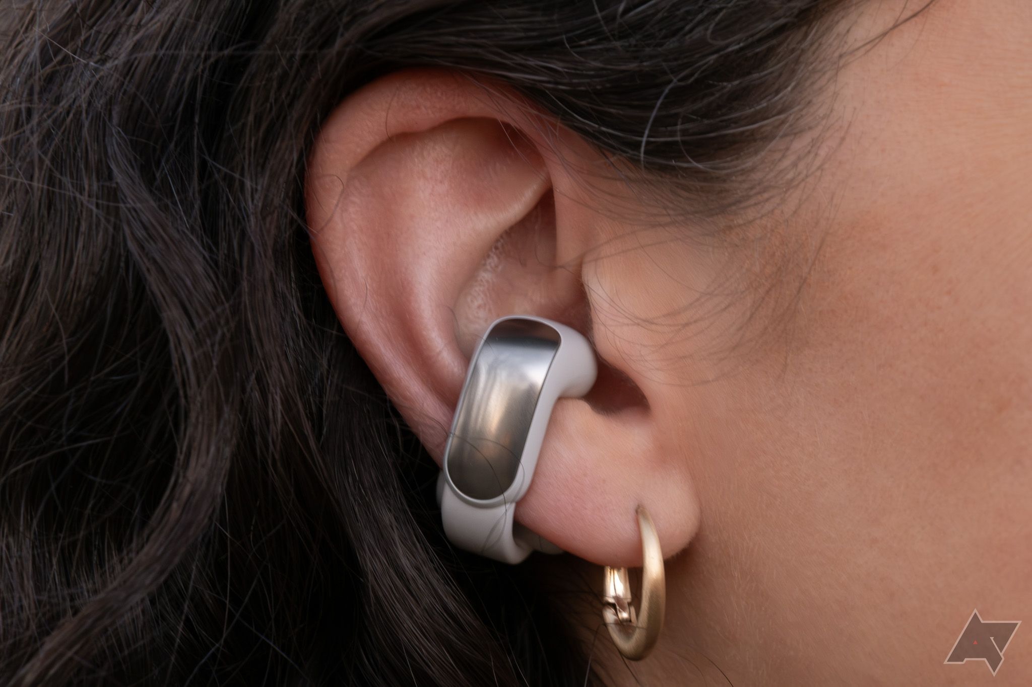 Um fone de ouvido Bose Ultra Open em uma orelha.