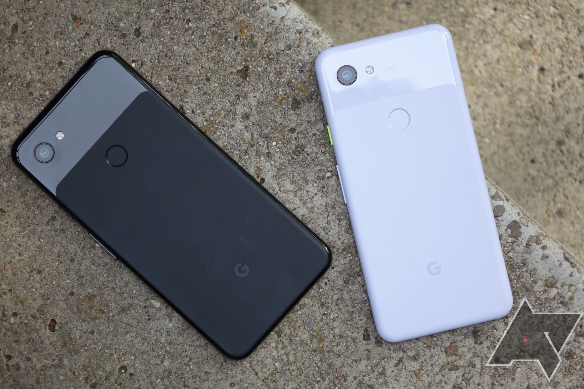 Um Google Pixel 3a e 3a XL em uma superfície de concreto