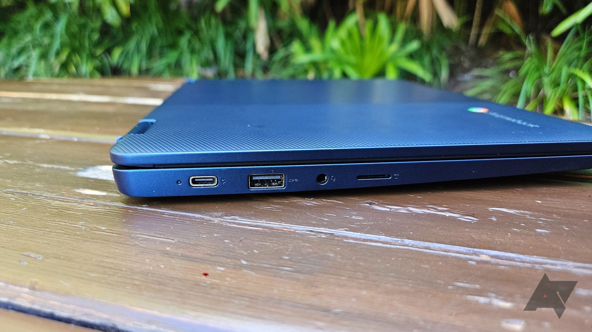 Um Chromebook Lenovo Flex 3i (8ª geração) fechado em uma mesa de madeira ao ar livre