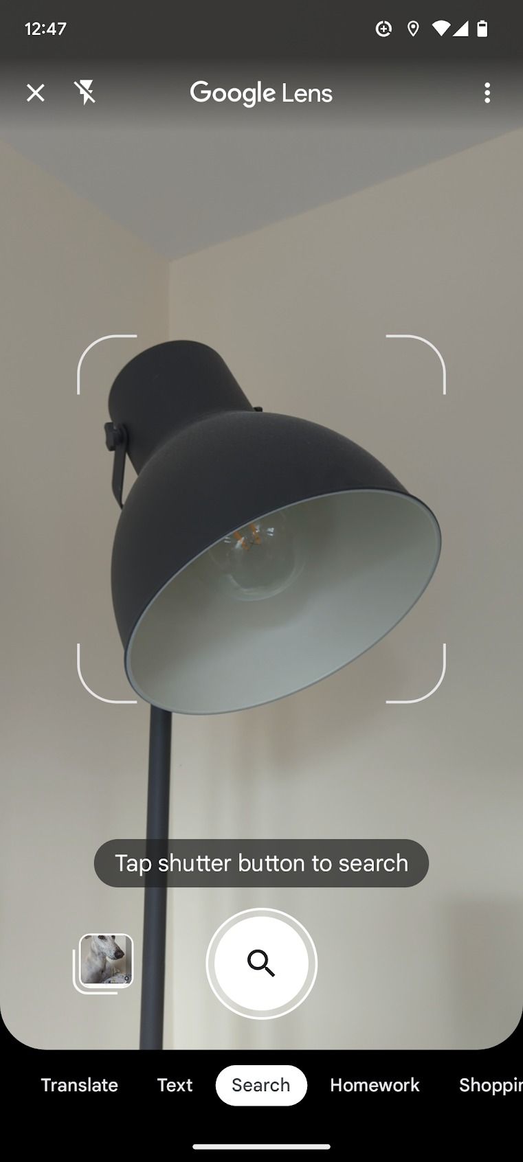 Uma captura de tela do aplicativo Google Lens é exibida, com o visor da câmera focado na digitalização de uma lâmpada.