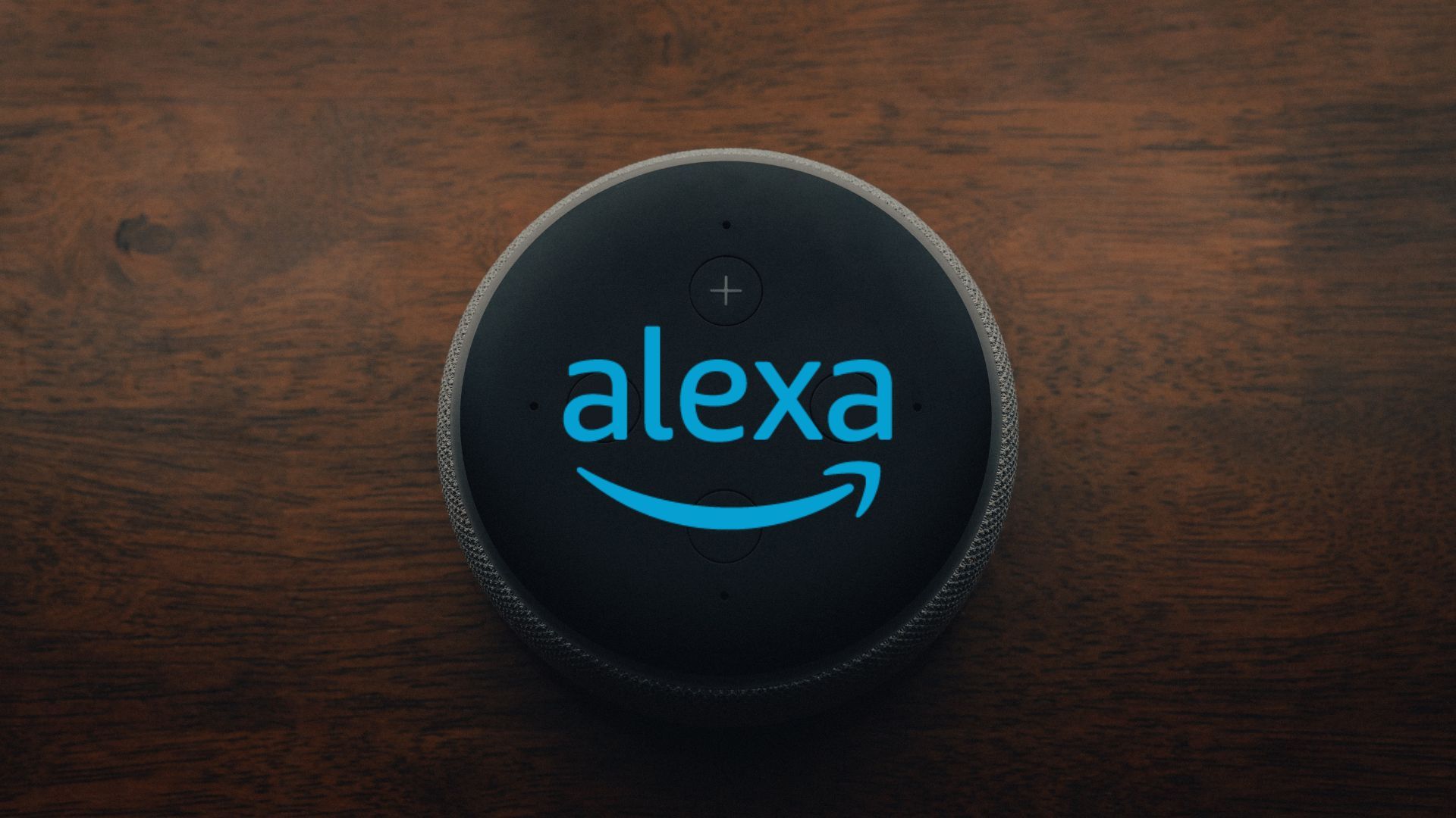 Um alto-falante inteligente em uma mesa de madeira.  O logotipo Alexa está iluminado na parte superior do alto-falante.
