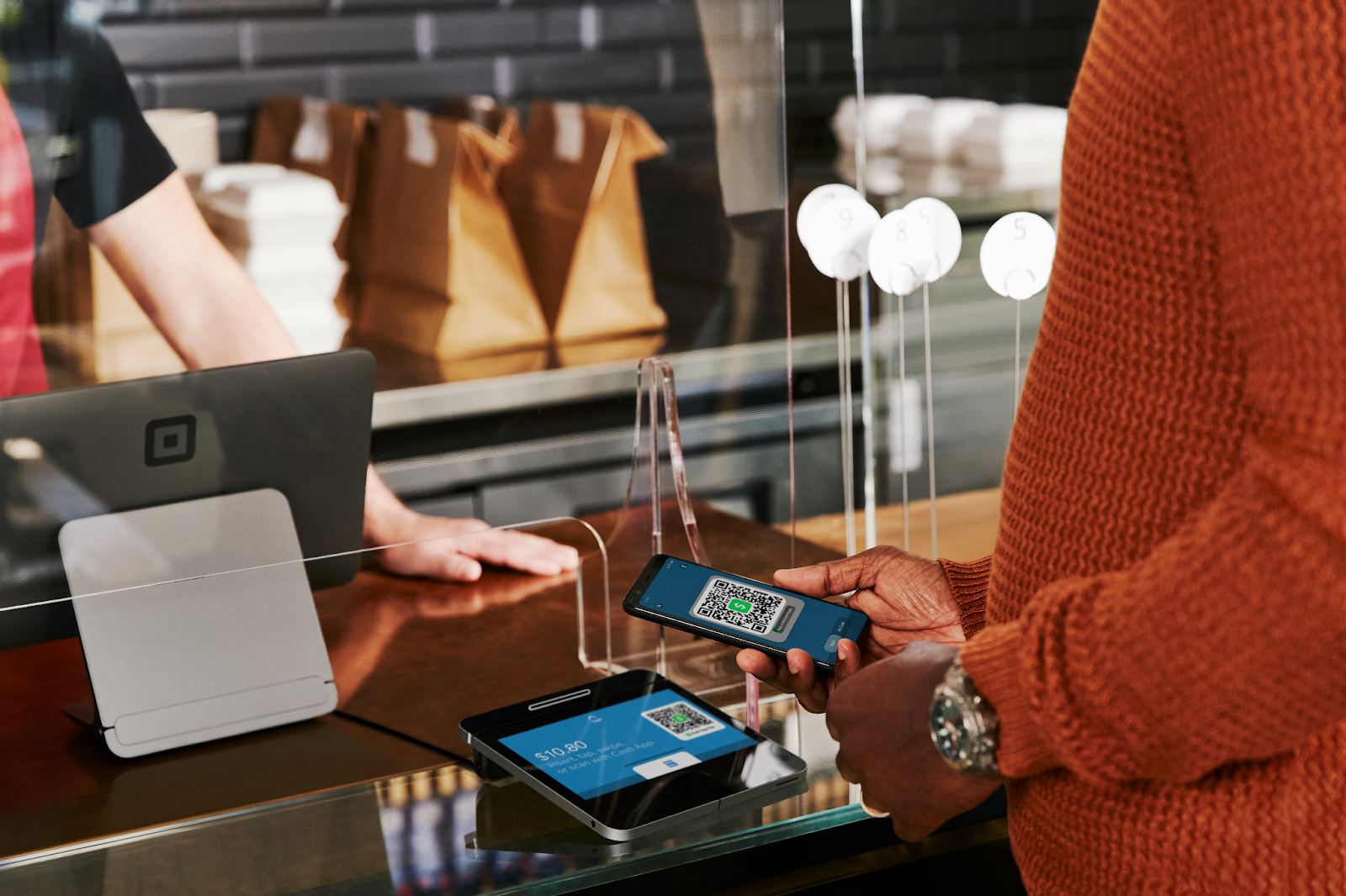 Uma pessoa confirma um pagamento do Cash App em uma caixa registradora.