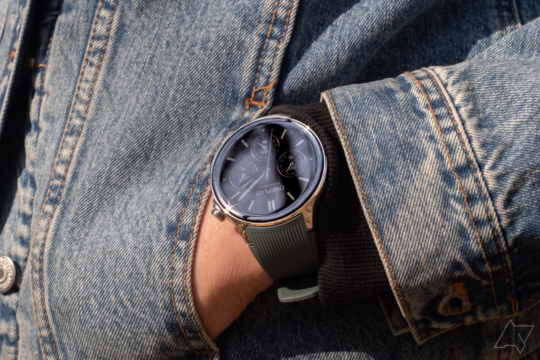 Um smartwatch no braço, com a mão no bolso de uma jaqueta jeans