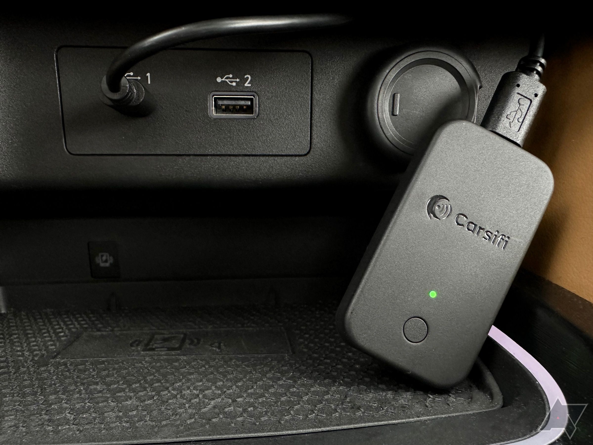 Adaptador Carsifi Wireless Android Auto conectado e apoiado no console do carro.