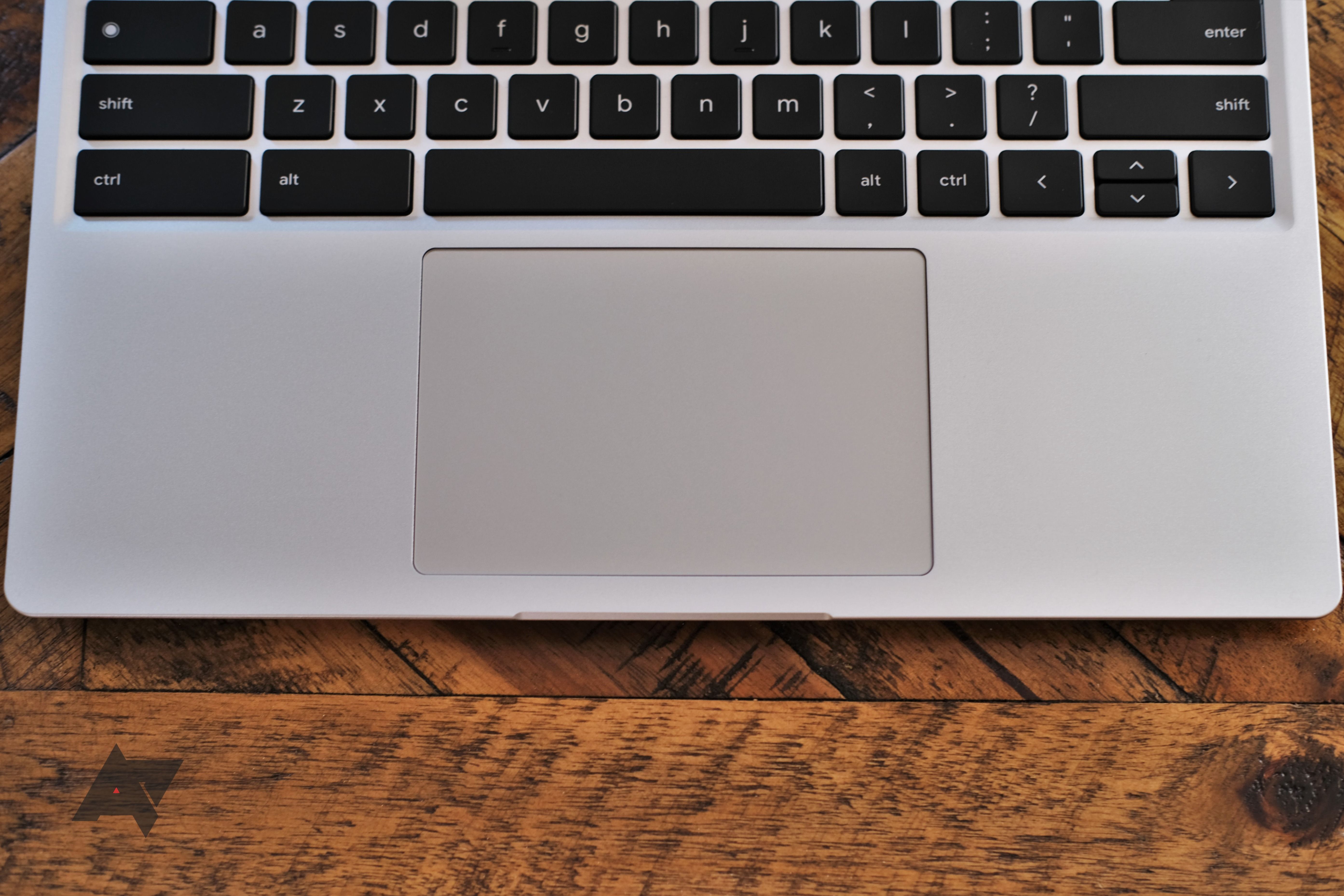 O touchpad e o teclado inferior de um Framework Laptop Chromebook Edition sobre uma mesa de madeira.