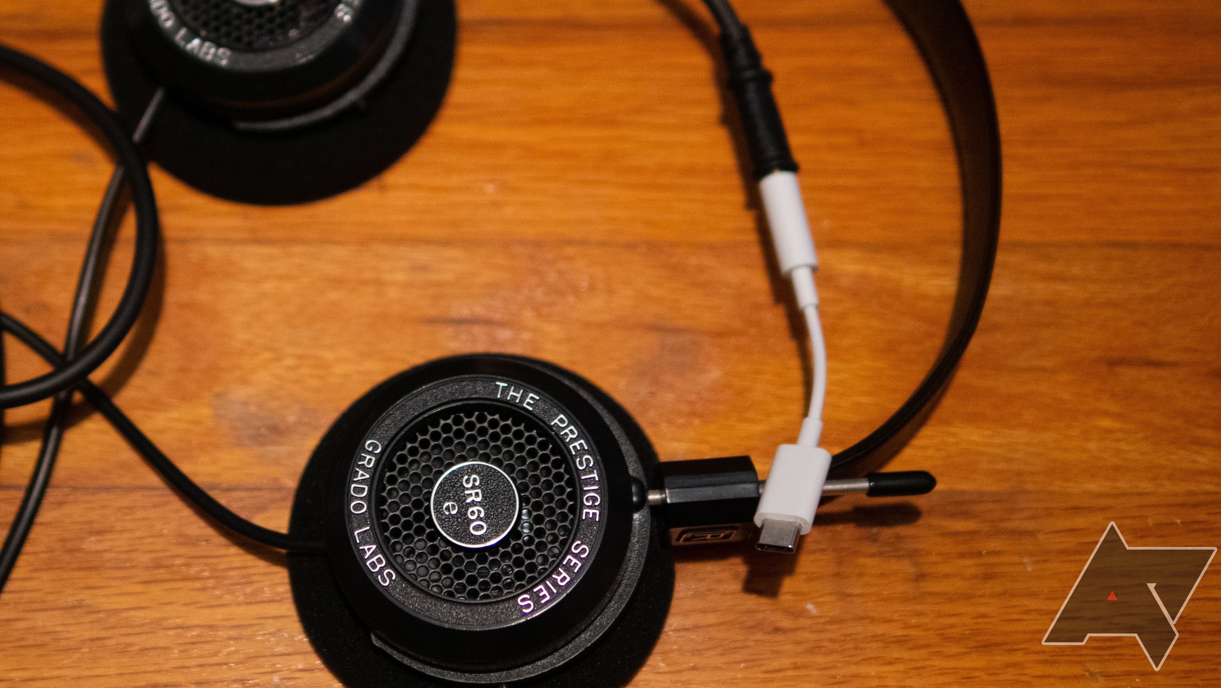 Uma imagem de fones de ouvido Grado com dongle DAC USB-C em uma mesa de madeira