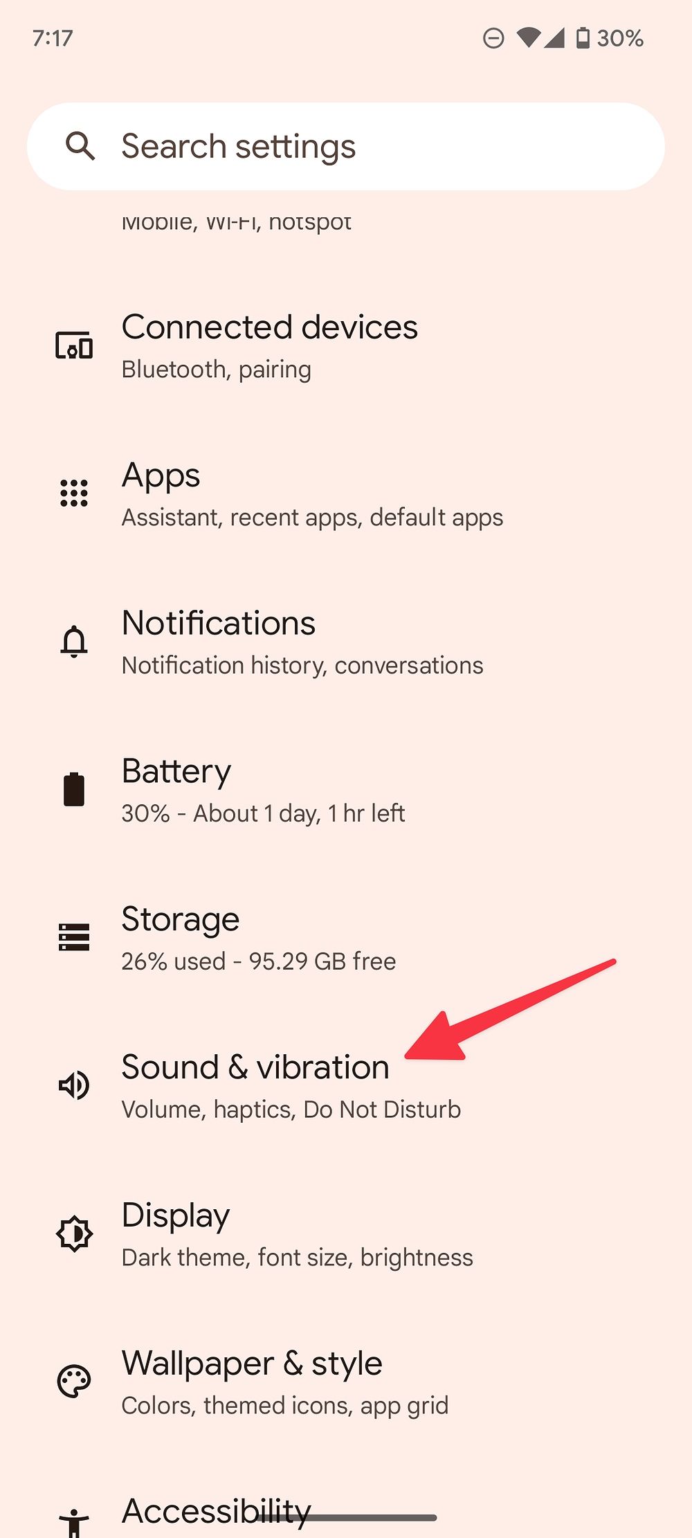 A captura de tela mostra a página de configurações do Android.  Uma seta aponta para 'Som e vibração'.