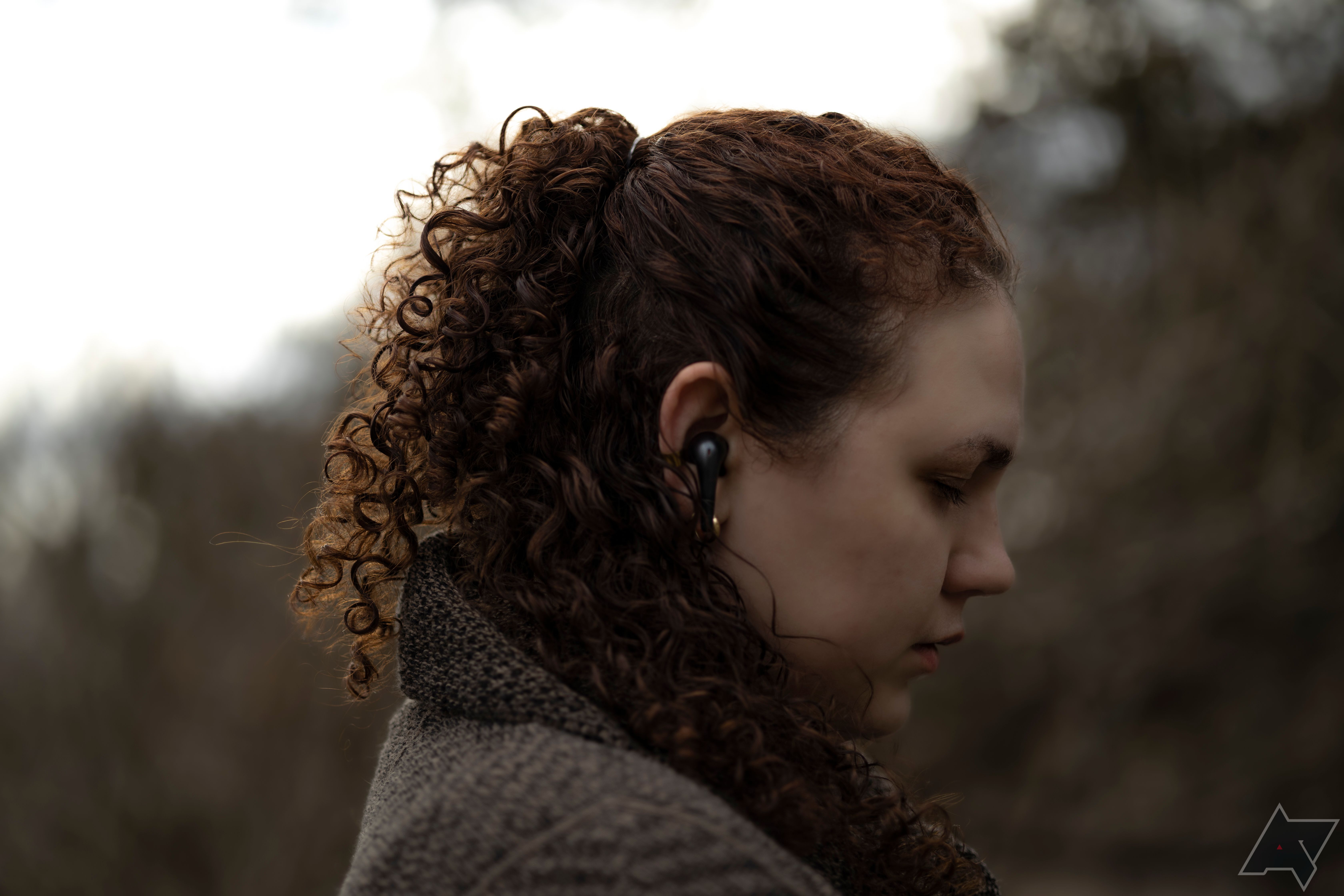 Perfil lateral de mulher usando fones de ouvido 1More Aero True Wireless ANC