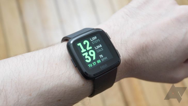 Um Fitbit Versa usado no pulso mostrando os passos dados e as calorias queimadas