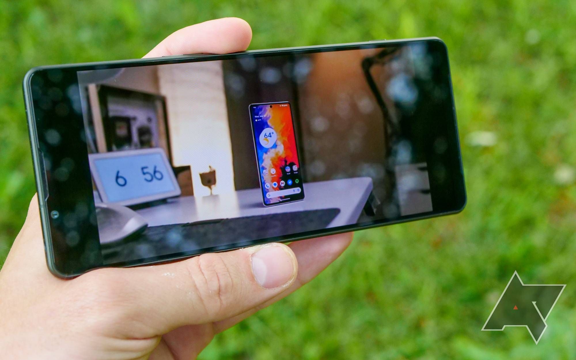 O Xperia 1 V segurado na mão do lado de fora reproduzindo um vídeo.