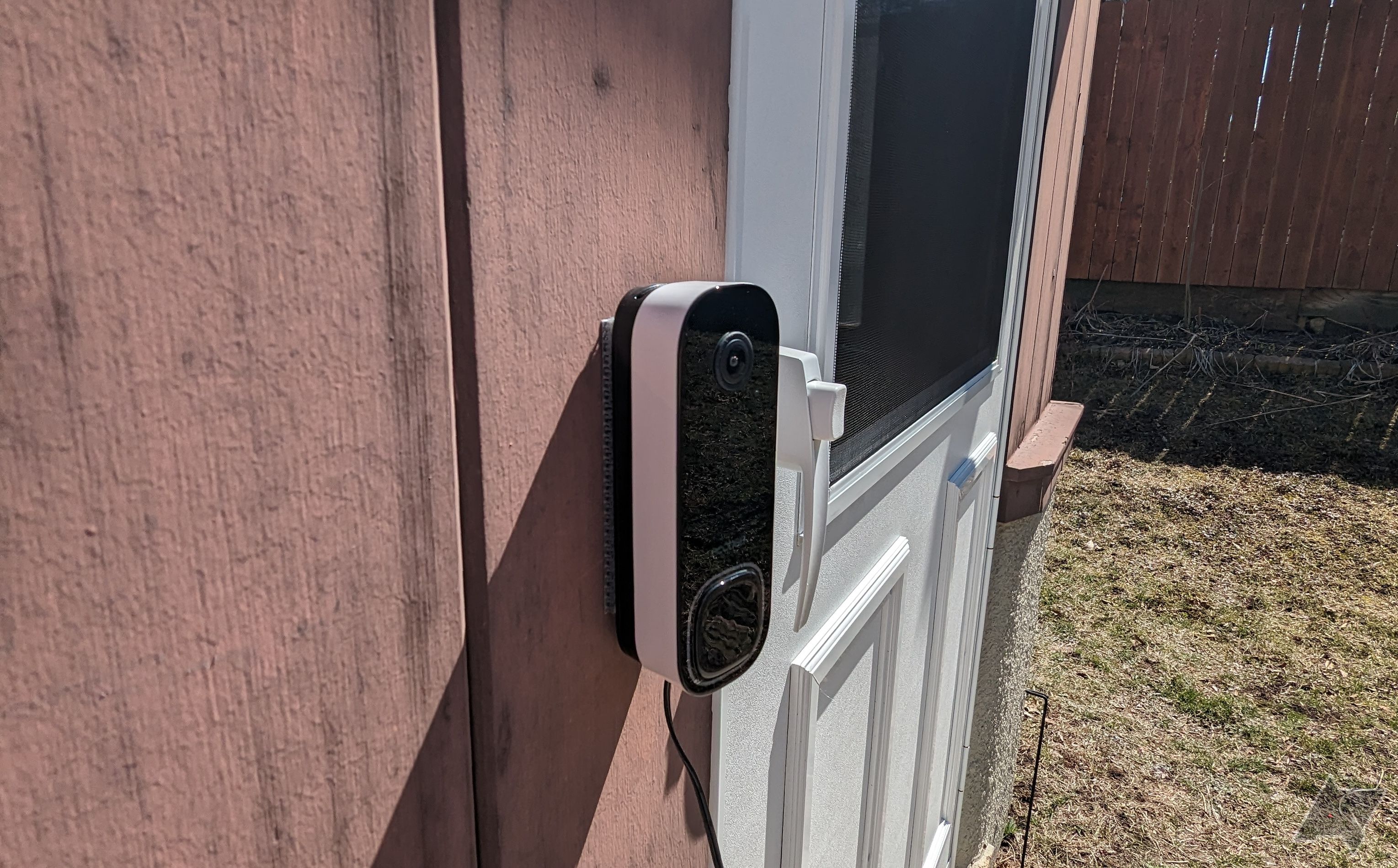 Ângulo mais à esquerda da câmera Ecobee Smart Doorbell (com fio) montada na parede ao lado da porta branca do pátio