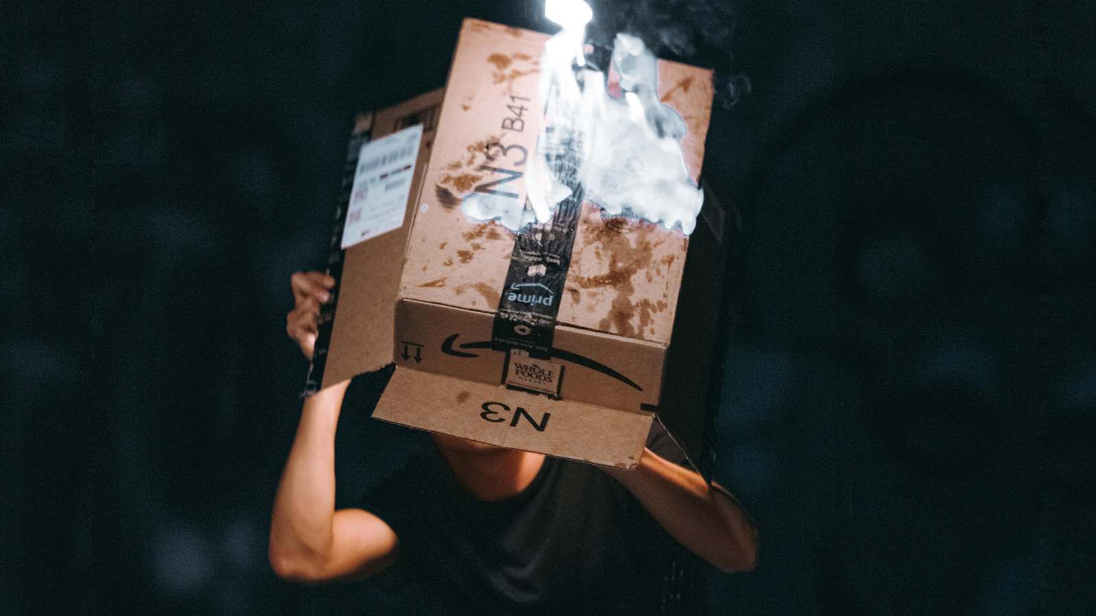 Uma pessoa olhando dentro de uma caixa de remessa danificada da Amazon