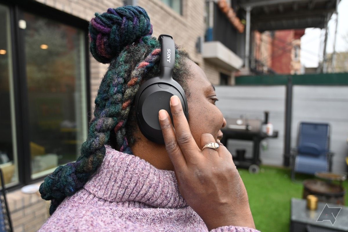 Mulher afro-americana interagindo com o painel de toque dos fones de ouvido Sony Ult Wear