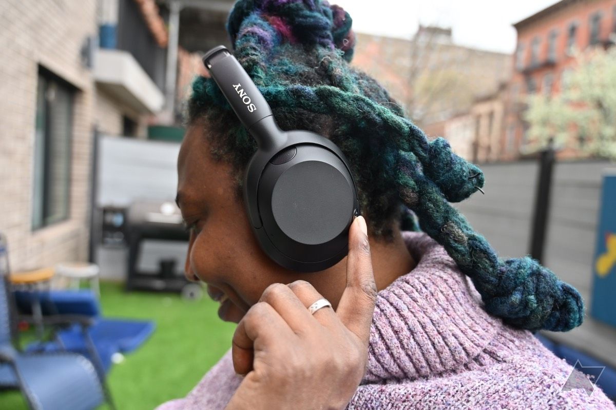 Mulher afro-americana tocando botão nos fones de ouvido Sony Ult Wear