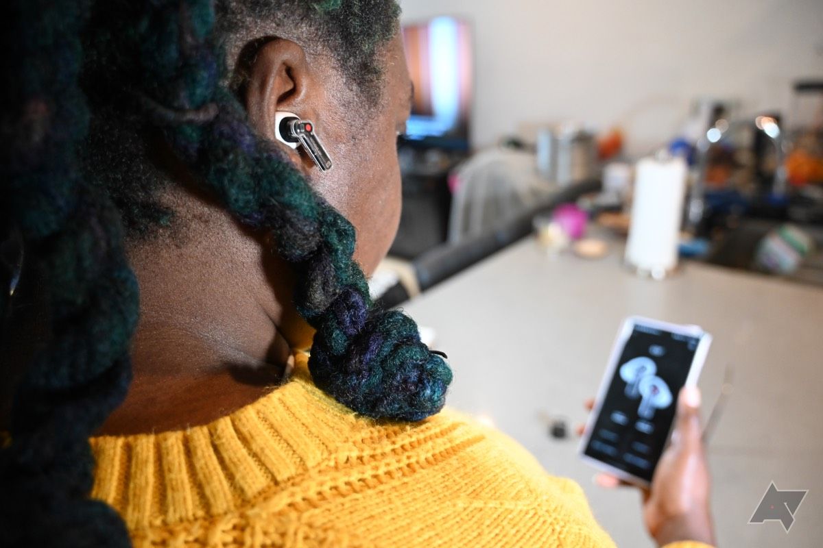 Mulher afro-americana usando Nothing Ear olhando o menu do ANC no aplicativo