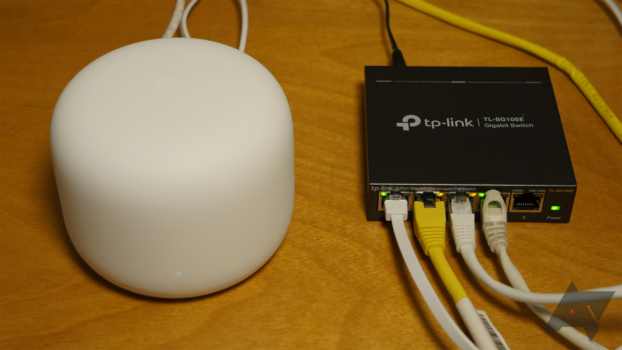 O roteador Google Nest Wifi conectado a um switch de rede para obter mais portas Ethernet.