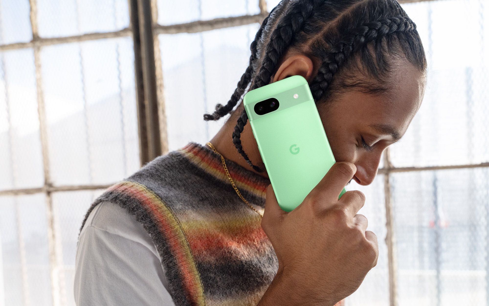 Uma pessoa fazendo uma ligação no Pixel 8a verde.